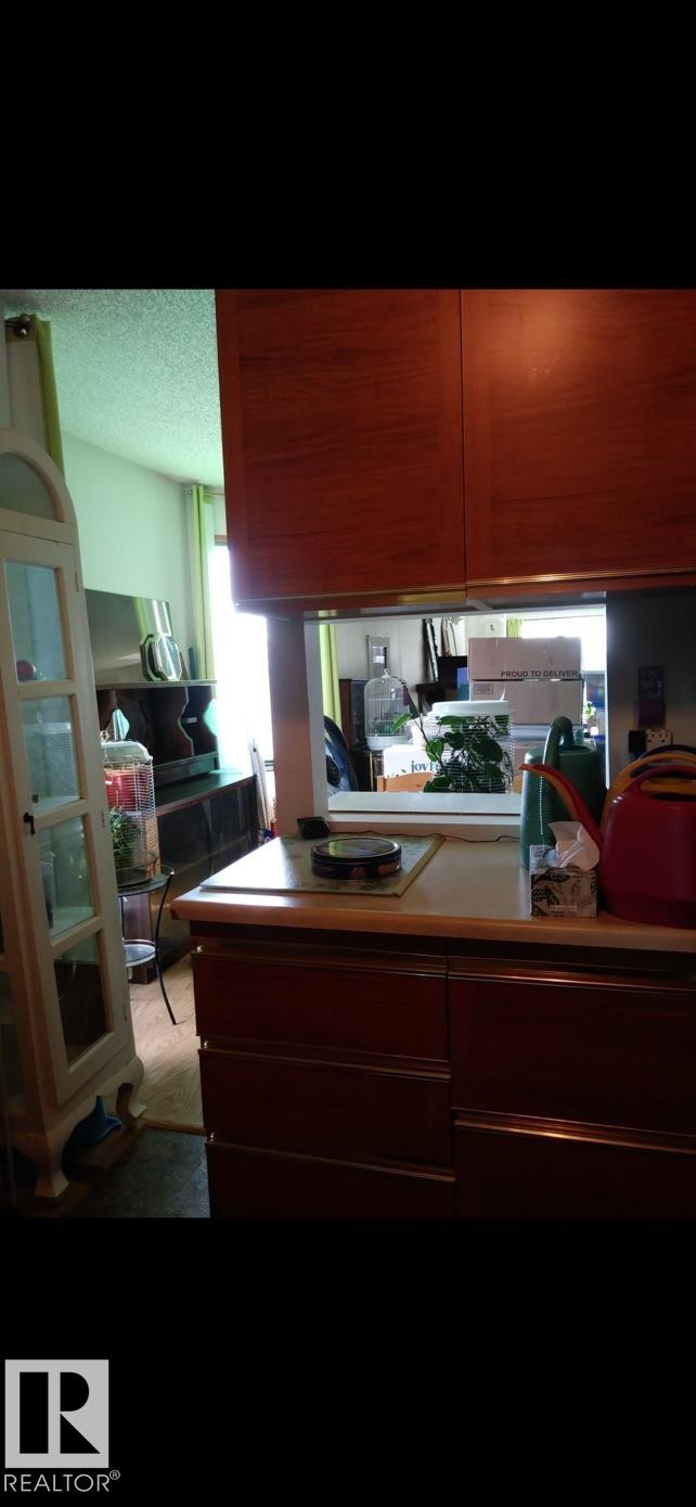 Kitchen featuring wood cabinetry and a light-colored countertop - 401 10743 107 Street Nw, Edmonton, AB - Indoor