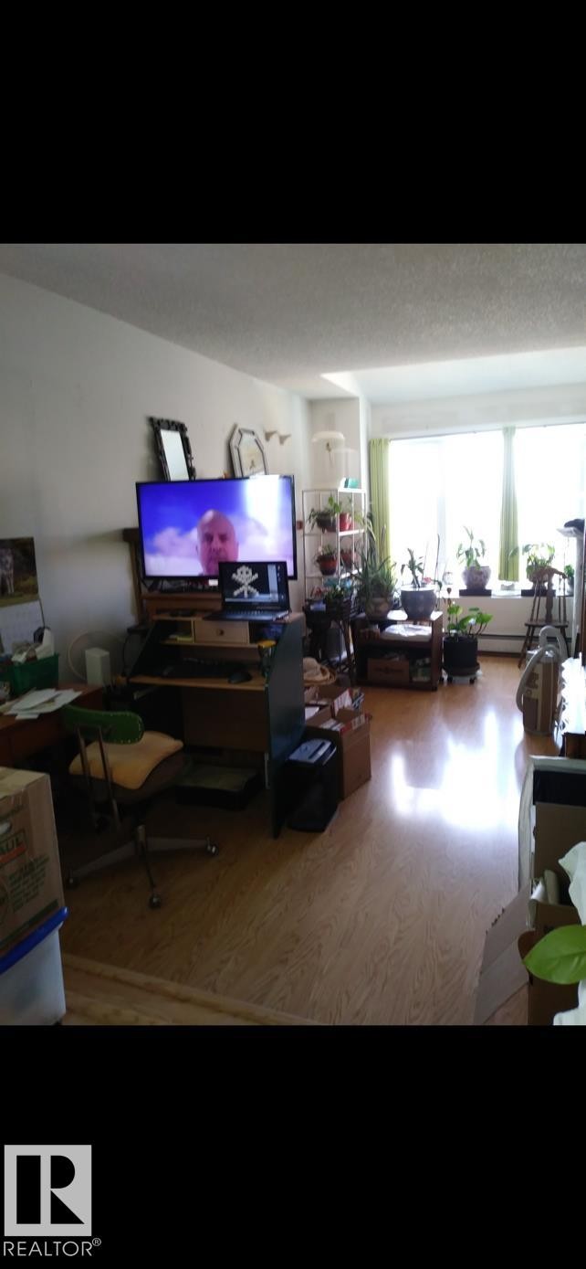 The living area features light-colored flooring and large windows, providing abundant natural light - 401 10743 107 Street Nw, Edmonton, AB - Indoor