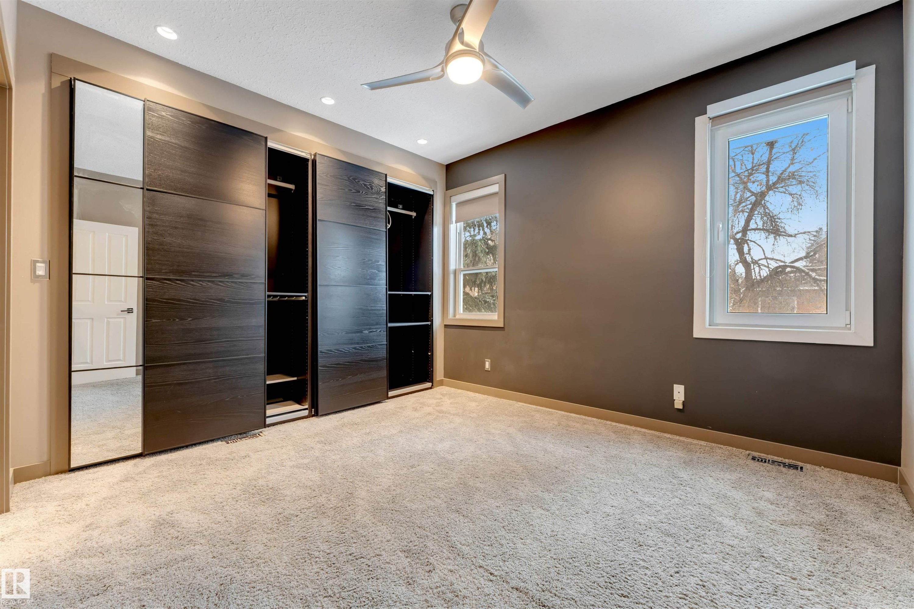 Unfurnished bedroom with multiple closets, light carpet, ceiling fan, and recessed lighting - 102 10711 83 Avenue, Edmonton, AB - Indoor Photo Showing Other Room
