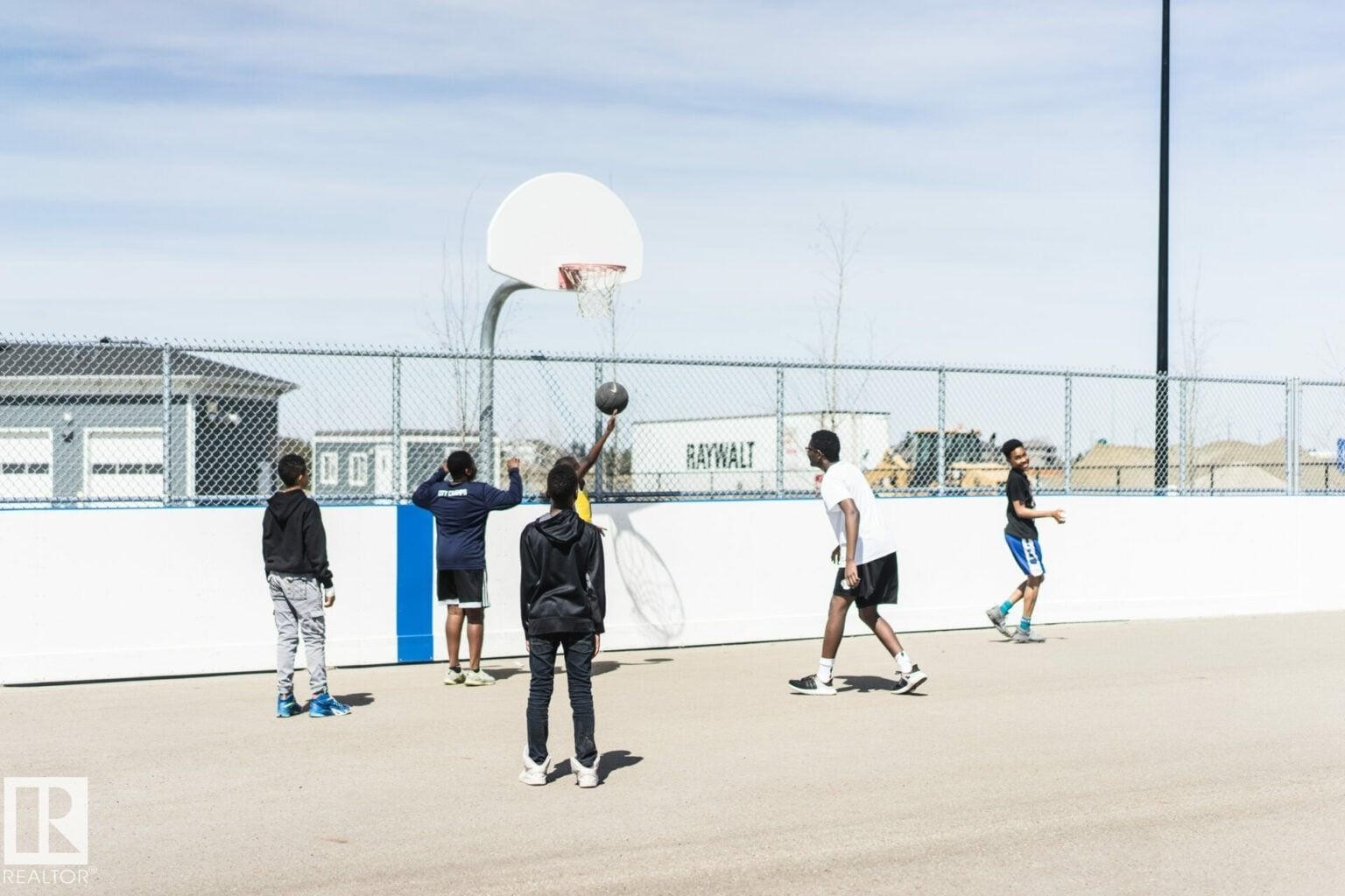 Community basketball court featuring a white backboard and chain-link fencing - 14 1140 Chappelle Boulevard, Edmonton, AB -