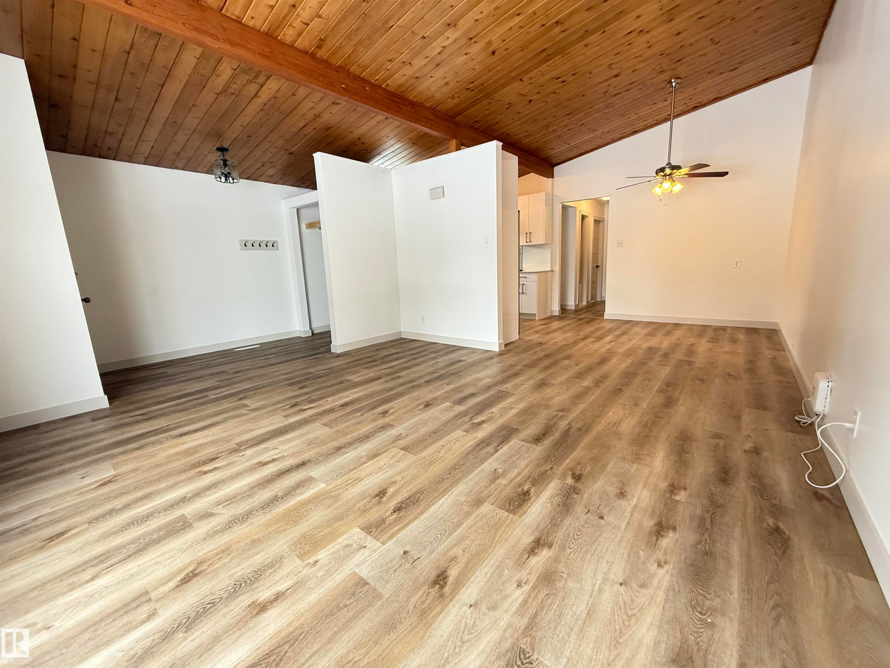 Unfurnished living room with light wood-type flooring, ceiling fan, and a high wooden beamed ceiling - 9034 60 Street, Edmonton, AB - Indoor Photo Showing Other Room