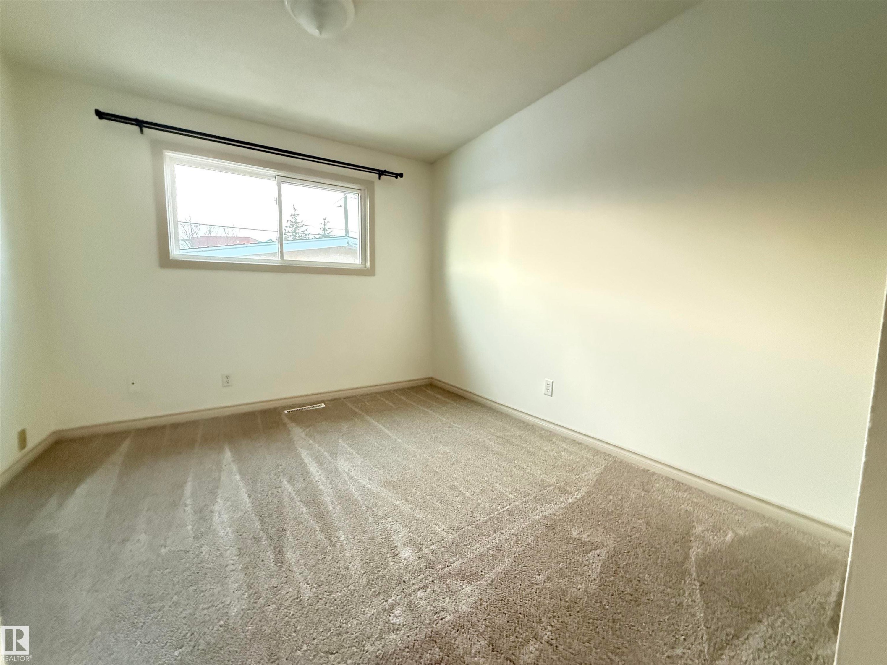Spare room featuring light carpet and baseboards - 9034 60 Street, Edmonton, AB - Indoor Photo Showing Other Room