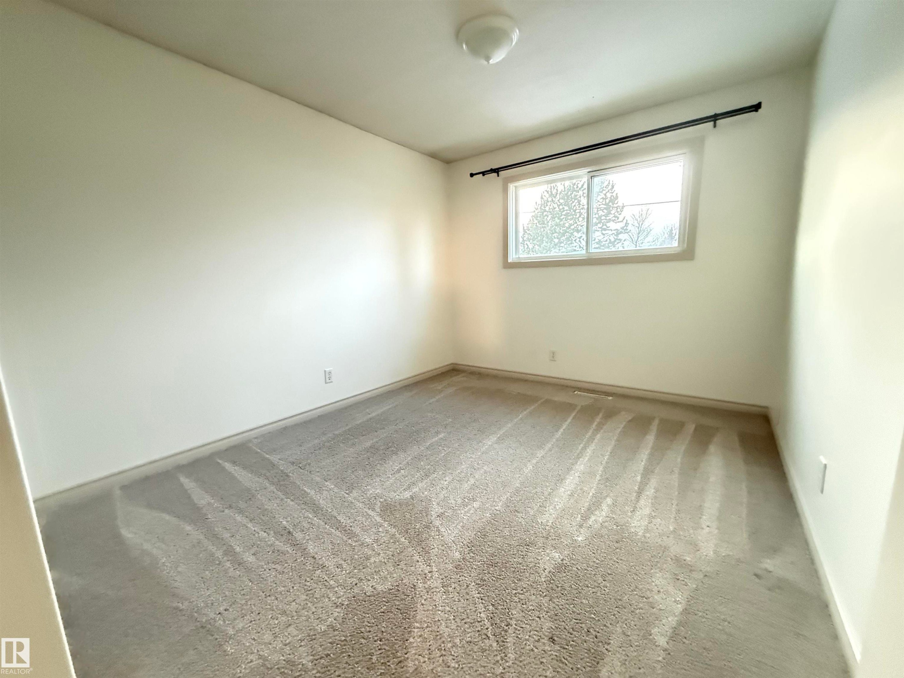Unfurnished room featuring light carpet and baseboards - 9034 60 Street, Edmonton, AB - Indoor Photo Showing Other Room