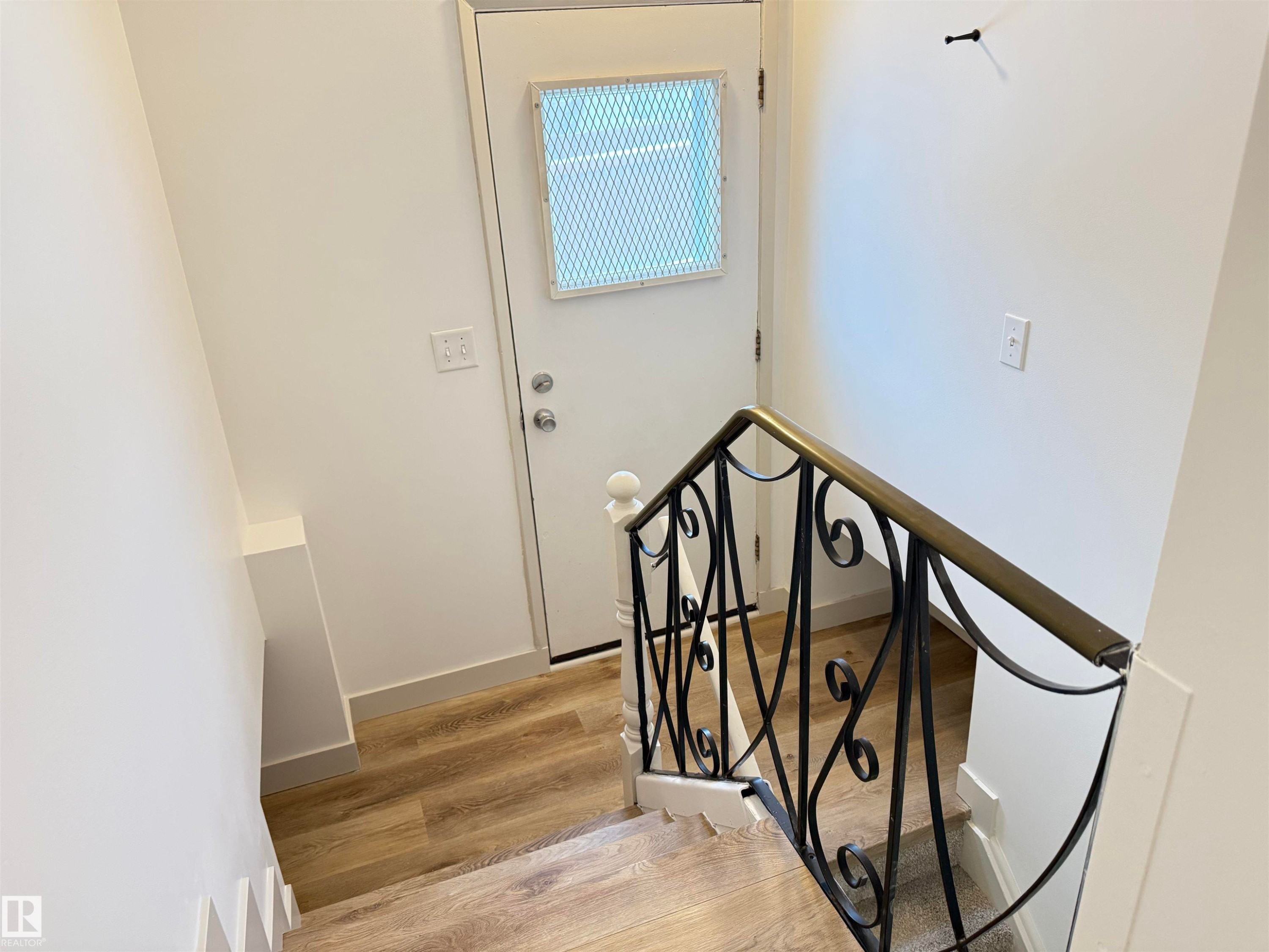 Stairs with wood finished floors and baseboards - 9034 60 Street, Edmonton, AB - Indoor Photo Showing Other Room