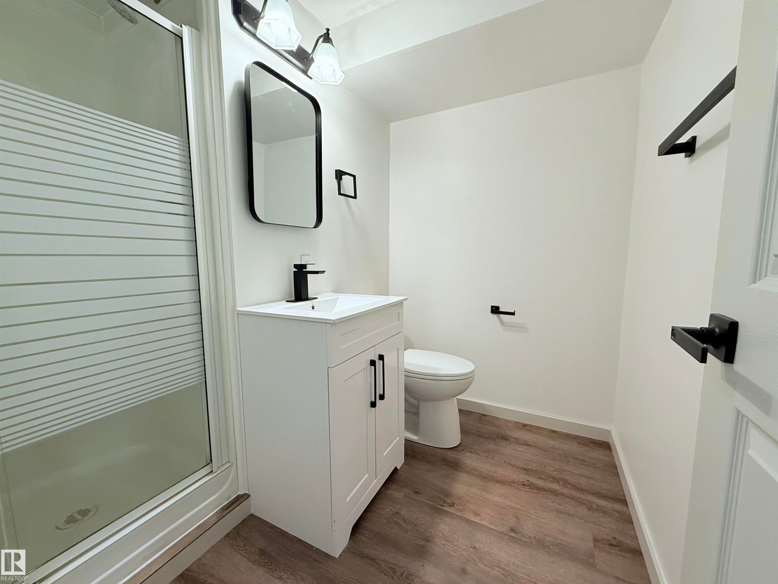 Bathroom featuring a shower stall, vanity, and dark wood-type flooring - 9034 60 Street, Edmonton, AB - Indoor Photo Showing Bathroom