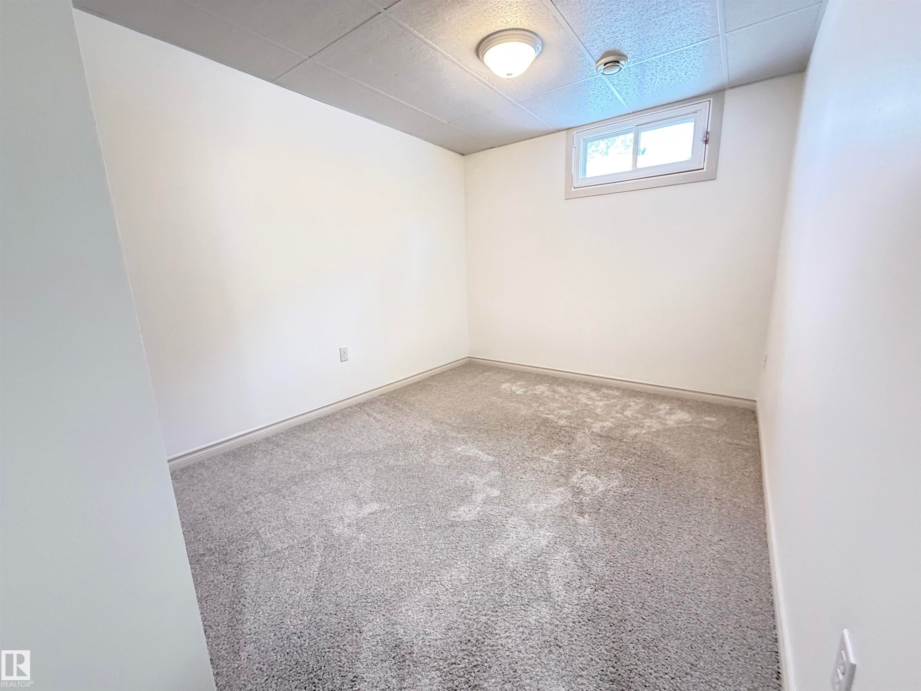 Spare room featuring carpet flooring and a drop ceiling - 9034 60 Street, Edmonton, AB - Indoor Photo Showing Other Room
