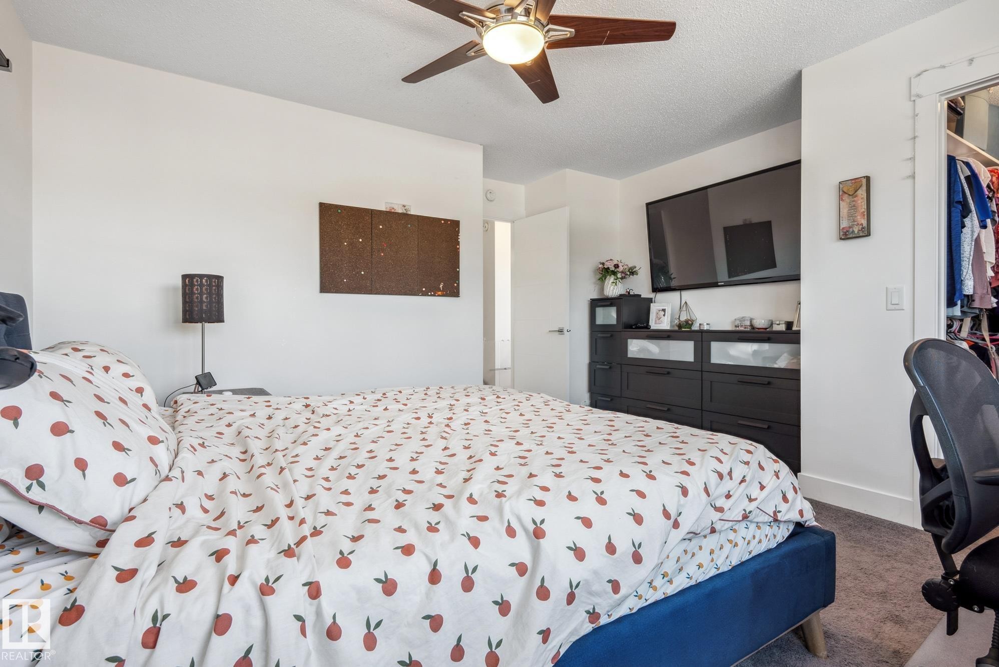 Bedroom with carpet floors, a ceiling fan, a textured ceiling, and a spacious closet - 76 330 Bulyea Road, Edmonton, AB - Indoor Photo Showing Bedroom