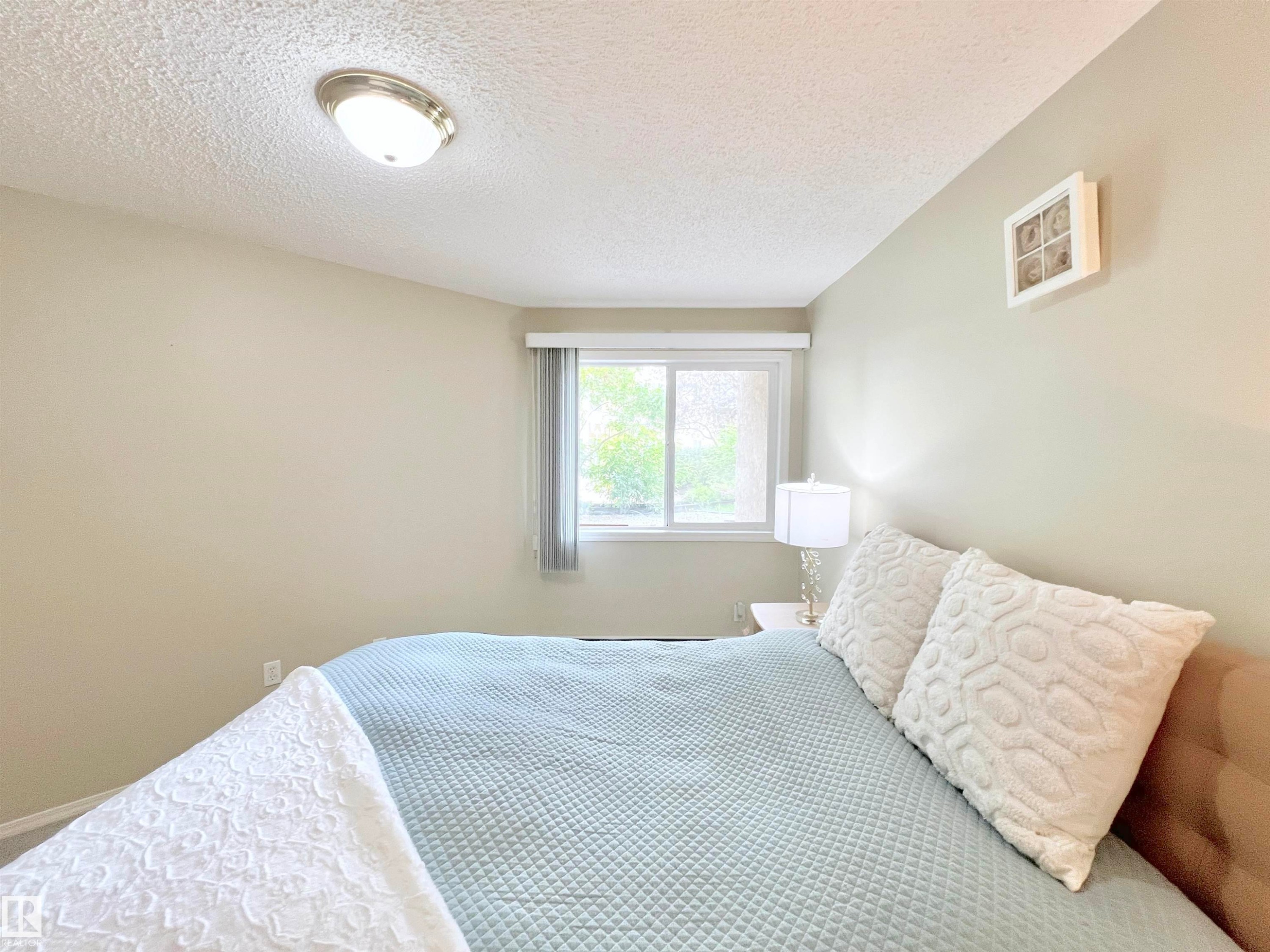 Bedroom with a textured ceiling - 110 10511 42 Avenue, Edmonton, AB - Indoor Photo Showing Bedroom