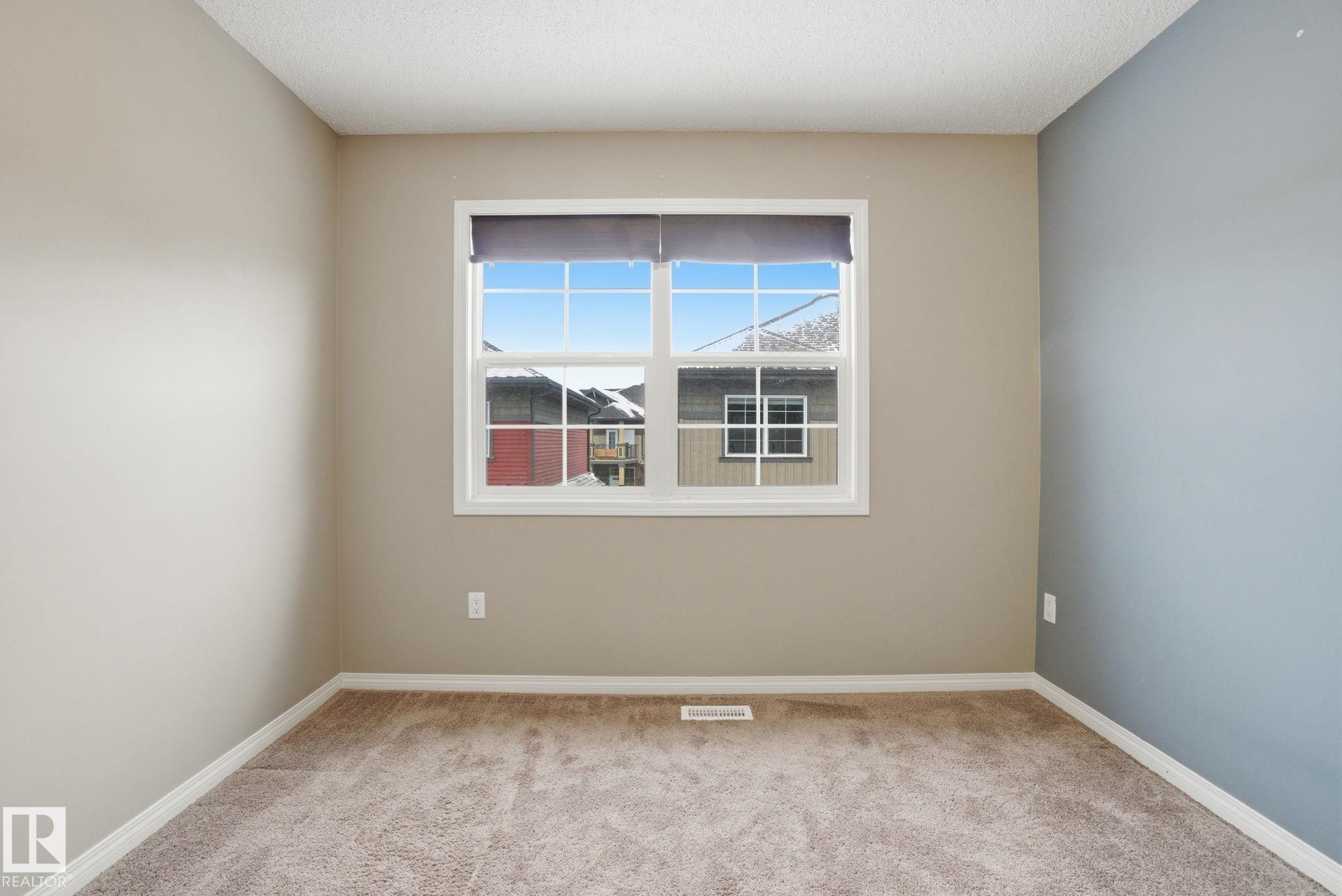 Unfurnished room featuring light colored carpet and baseboards - 71 4029 Orchards Drive, Edmonton, AB - Indoor Photo Showing Other Room