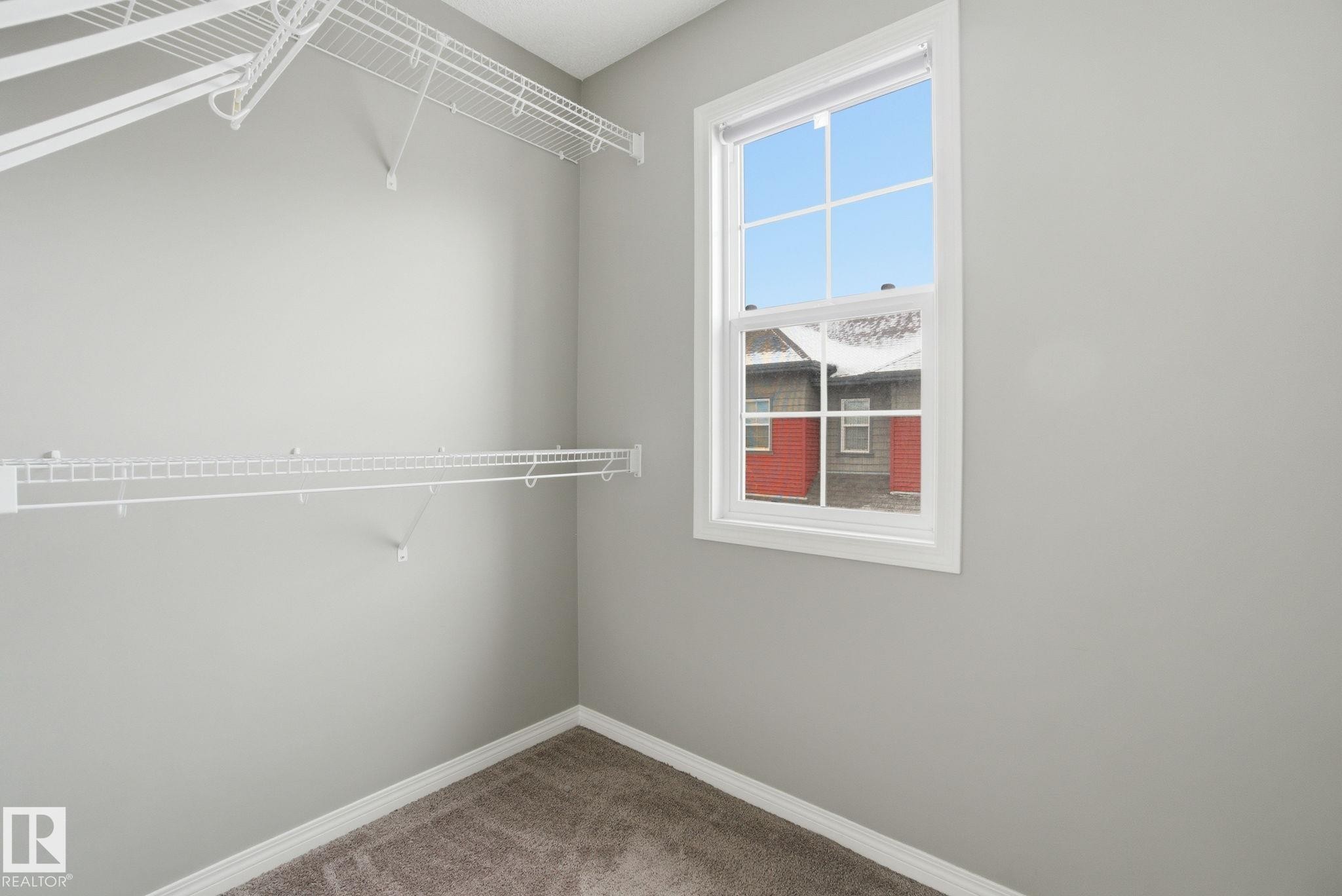 Walk in closet featuring carpet floors - 71 4029 Orchards Drive, Edmonton, AB - Indoor With Storage