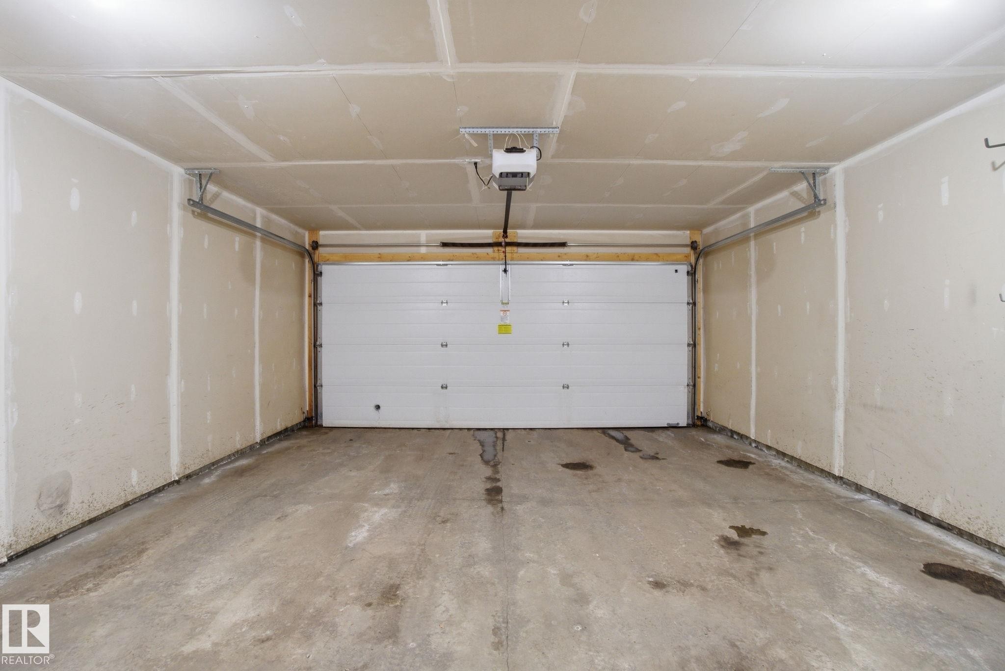 Garage featuring a garage door opener - 71 4029 Orchards Drive, Edmonton, AB - Indoor Photo Showing Garage