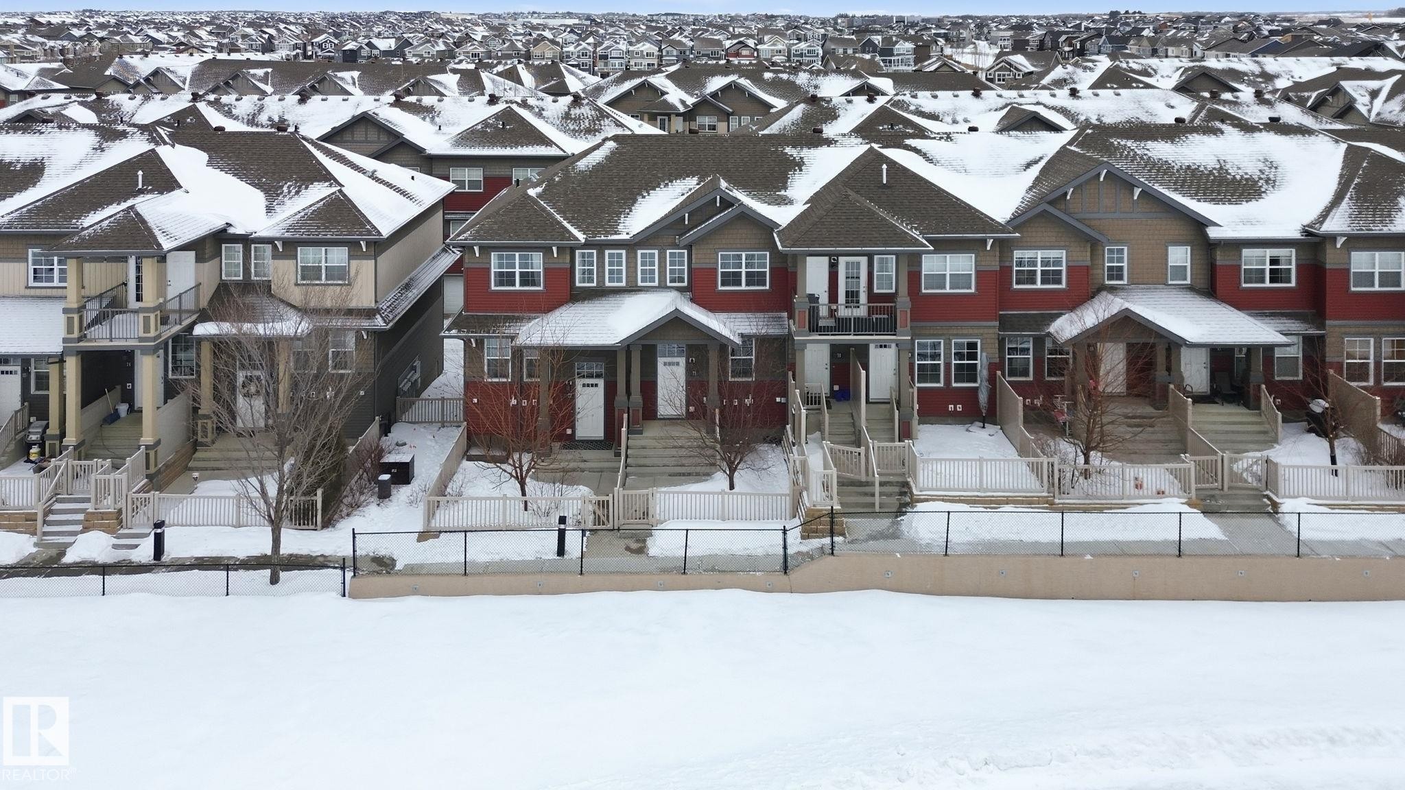 Craftsman-style house featuring a fenced front yard and a residential view - 71 4029 Orchards Drive, Edmonton, AB - Outdoor With Facade