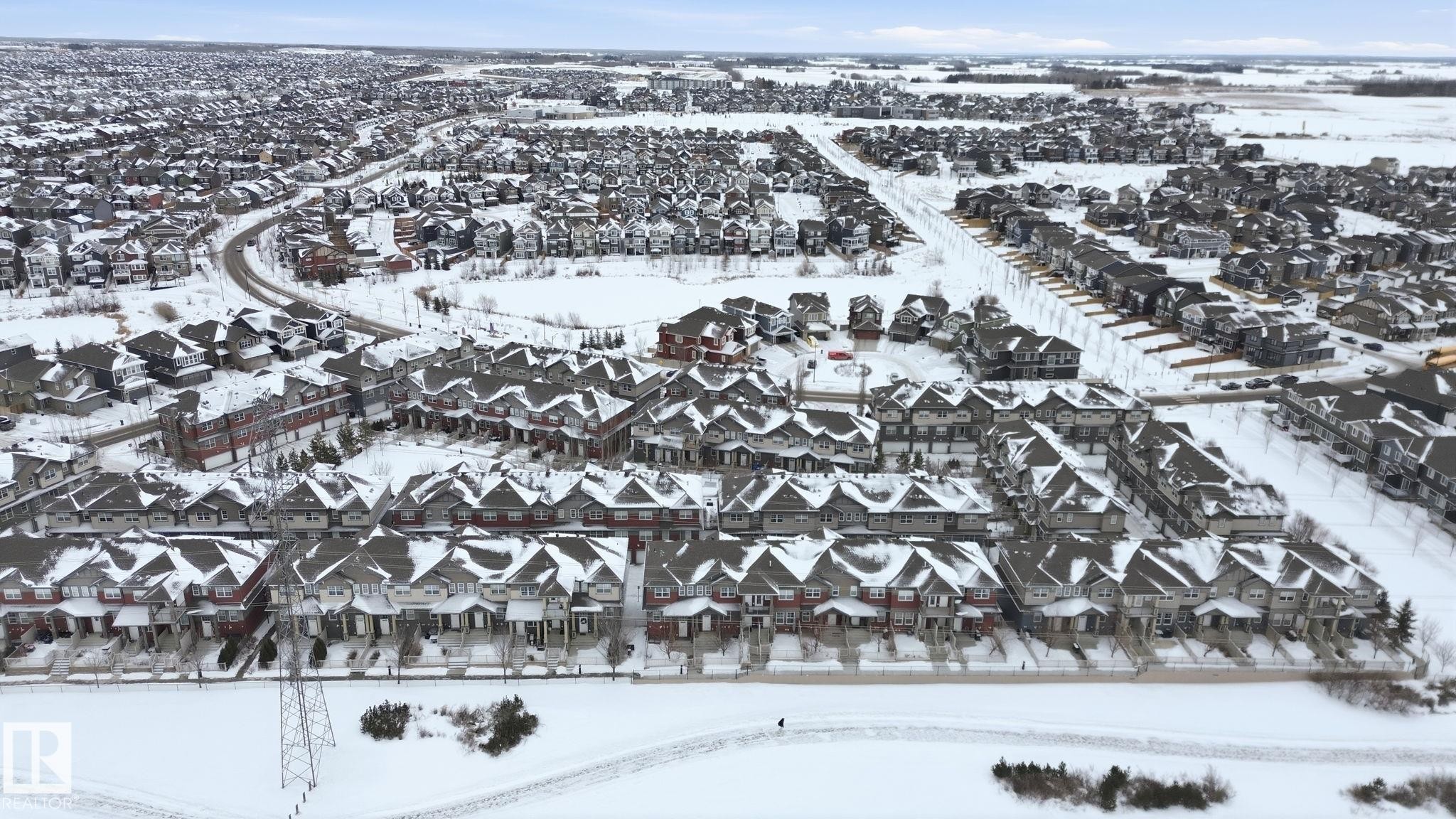 Snowy aerial view with a residential view - 71 4029 Orchards Drive, Edmonton, AB - Outdoor With View