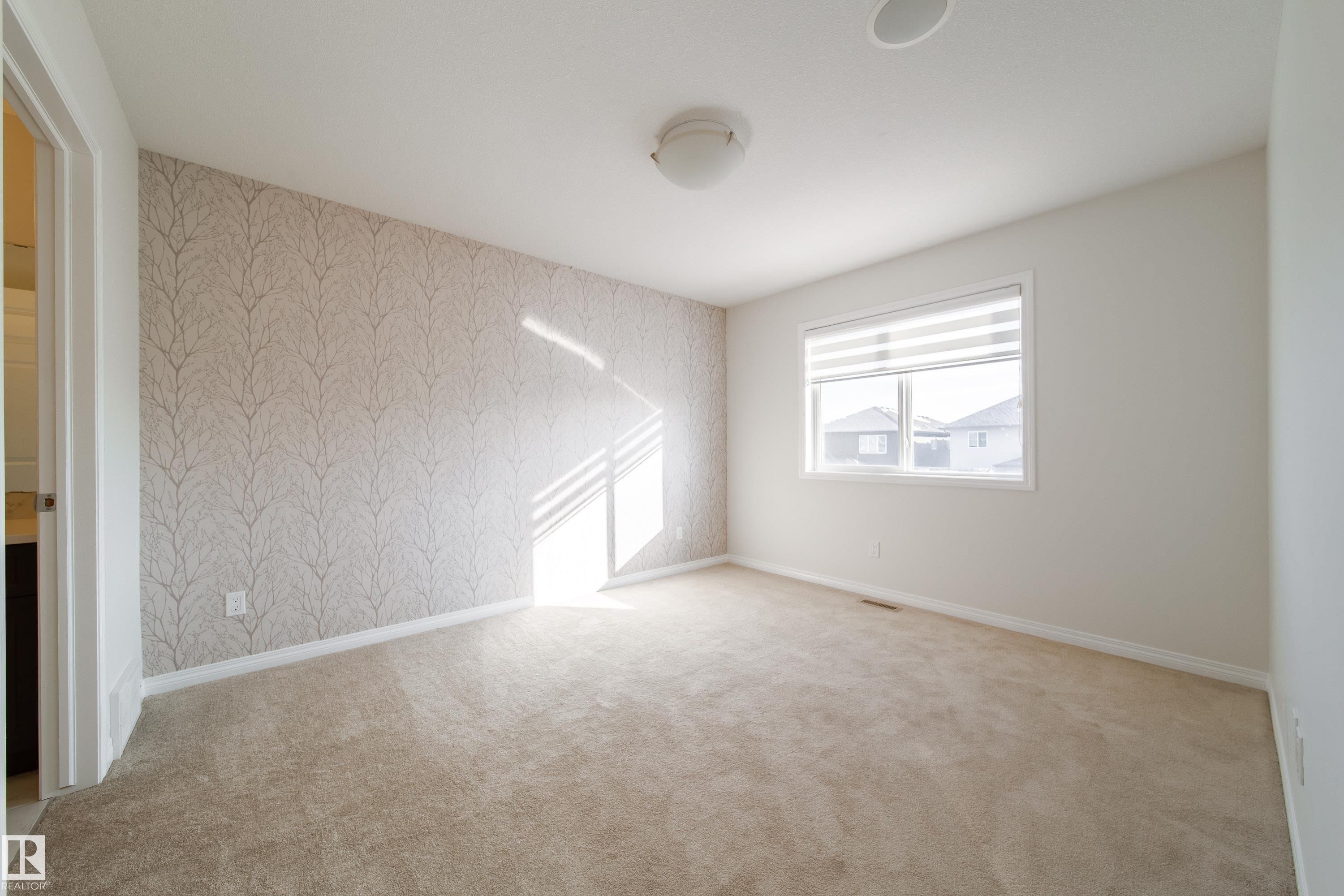 Empty room with wallpapered walls and light carpet - 1199 Watt Drive, Edmonton, AB - Indoor Photo Showing Other Room