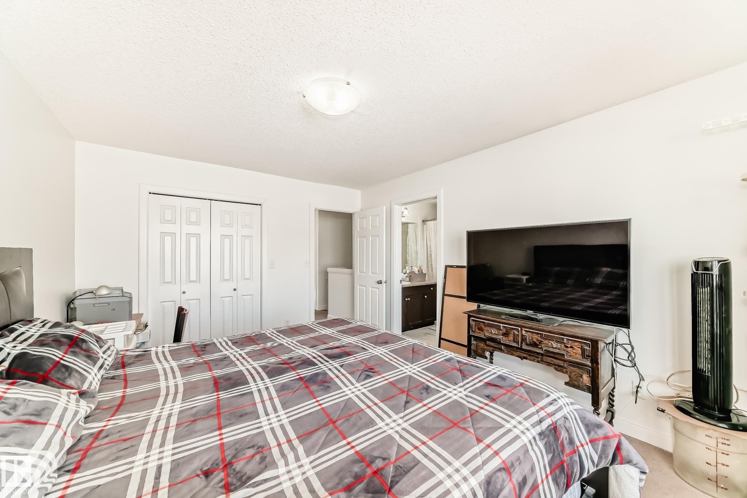 Bedroom with light colored carpet, a closet, a textured ceiling, and ensuite bathroom - 17357 8A Avenue, Edmonton, AB