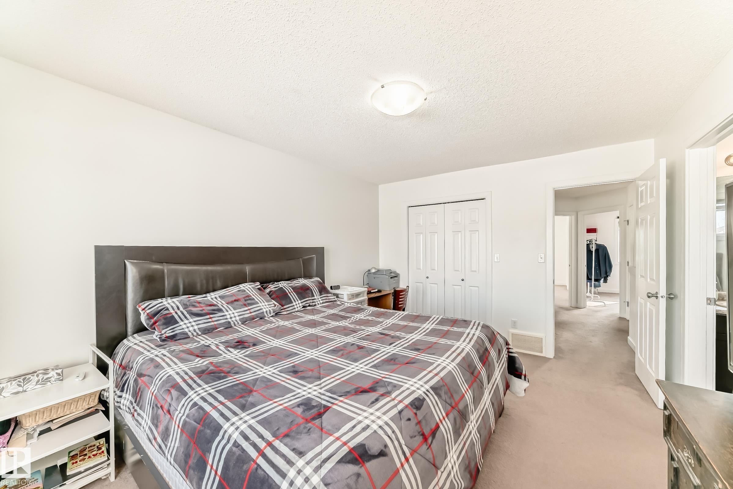 Bedroom with light colored carpet, a textured ceiling, and a closet - 17357 8A Avenue, Edmonton, AB
