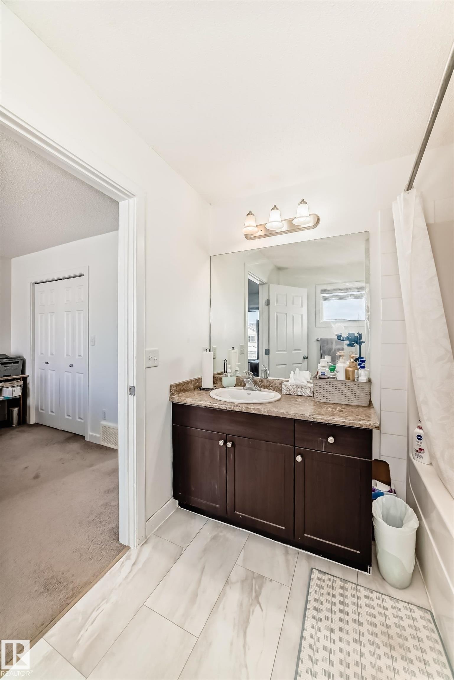 Full bath featuring vanity, shower / bathtub combination with curtain, and light carpet - 17357 8A Avenue, Edmonton, AB
