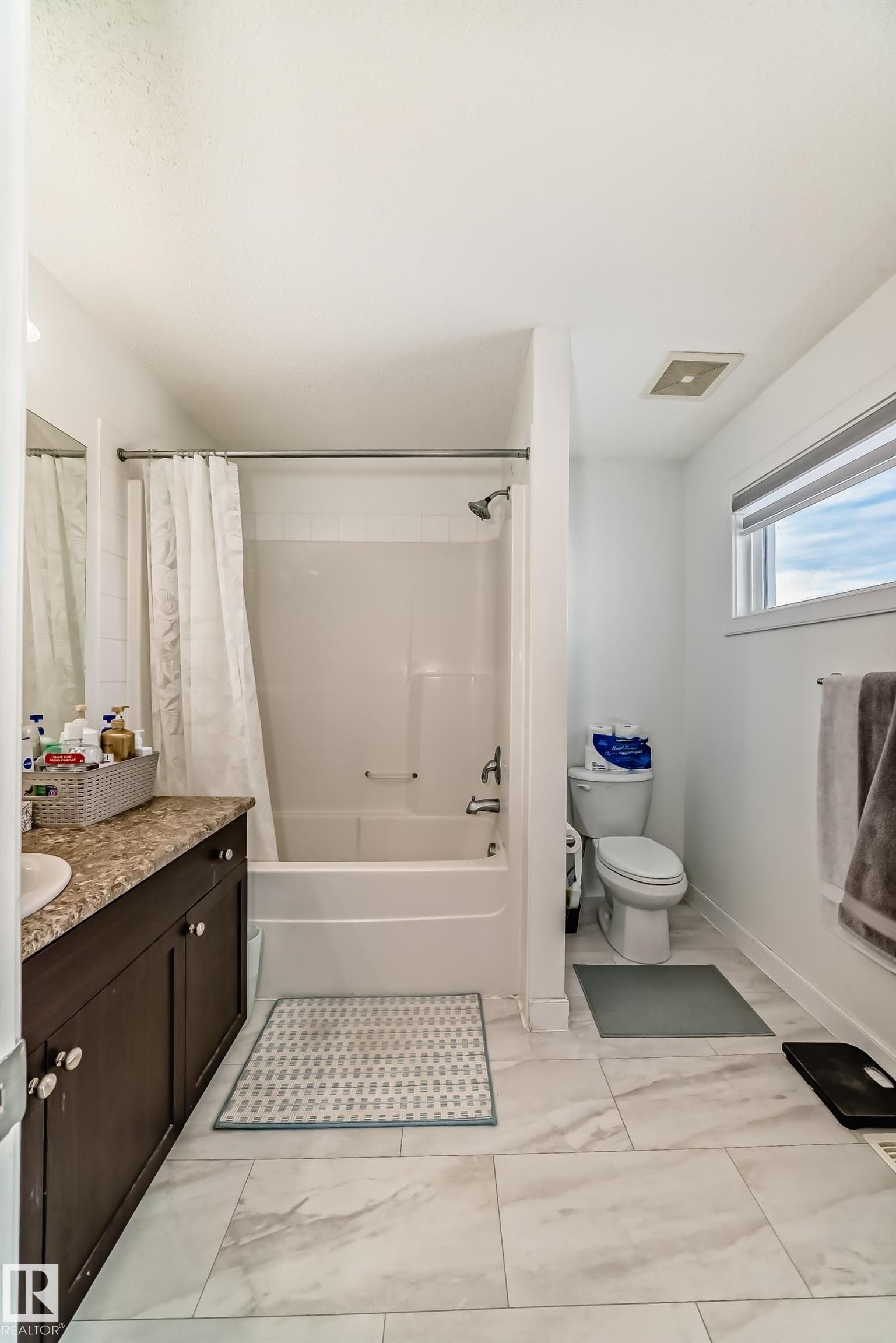 Bathroom featuring vanity and shower / bathtub combination with curtain - 17357 8A Avenue, Edmonton, AB