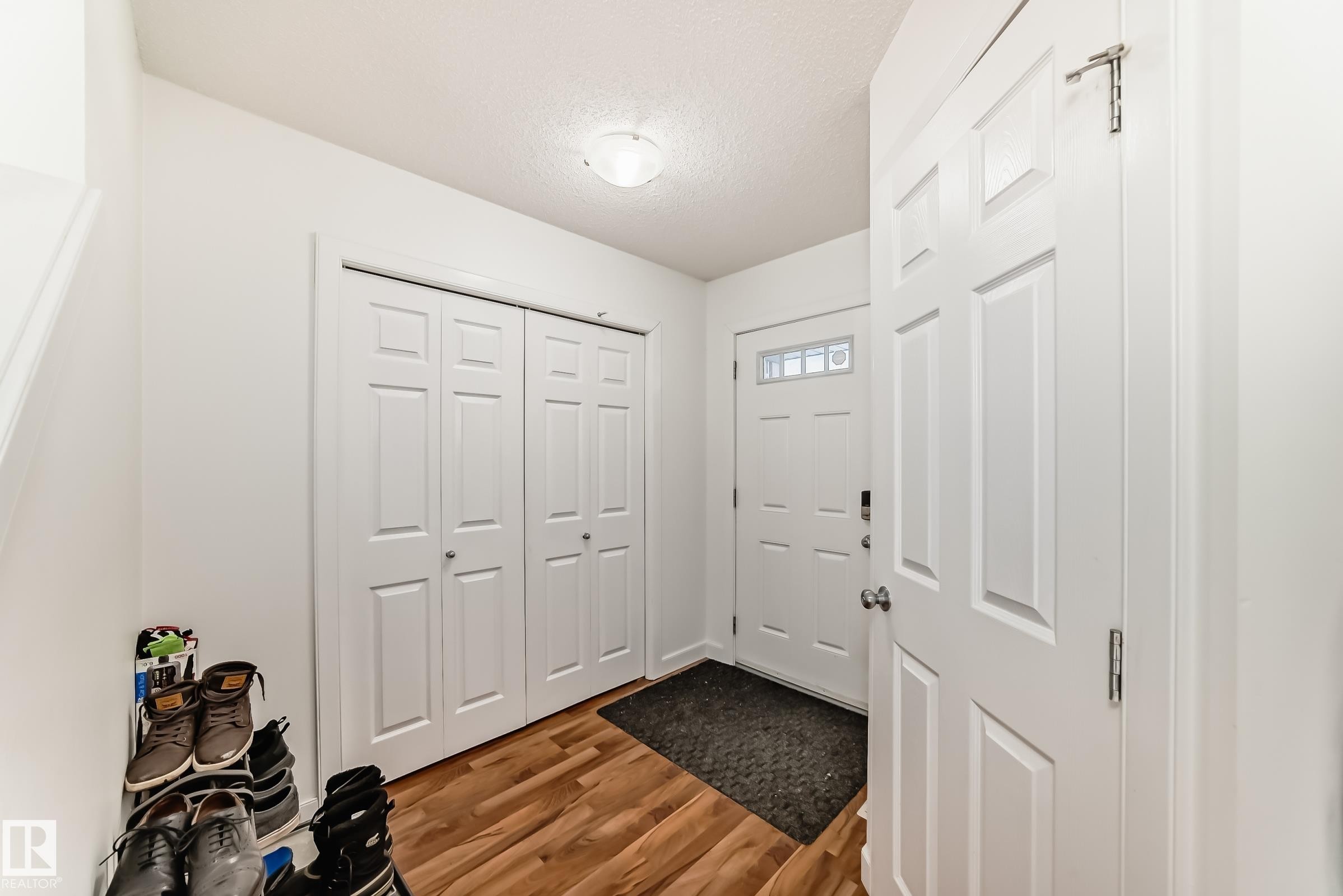 Entrance foyer featuring wood finished floors and a textured ceiling - 17357 8A Avenue, Edmonton, AB