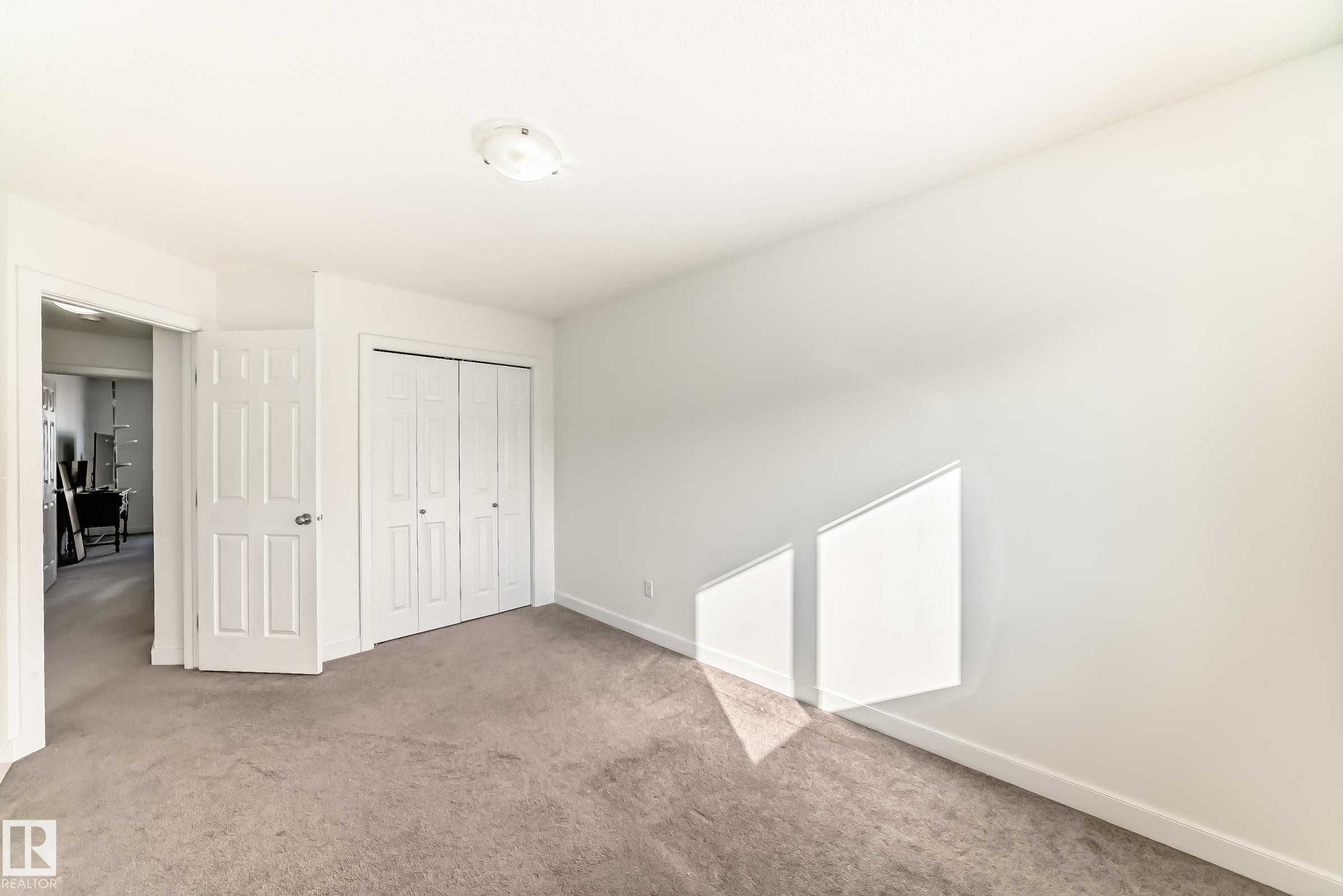 Unfurnished bedroom with light carpet and a closet - 17357 8A Avenue, Edmonton, AB