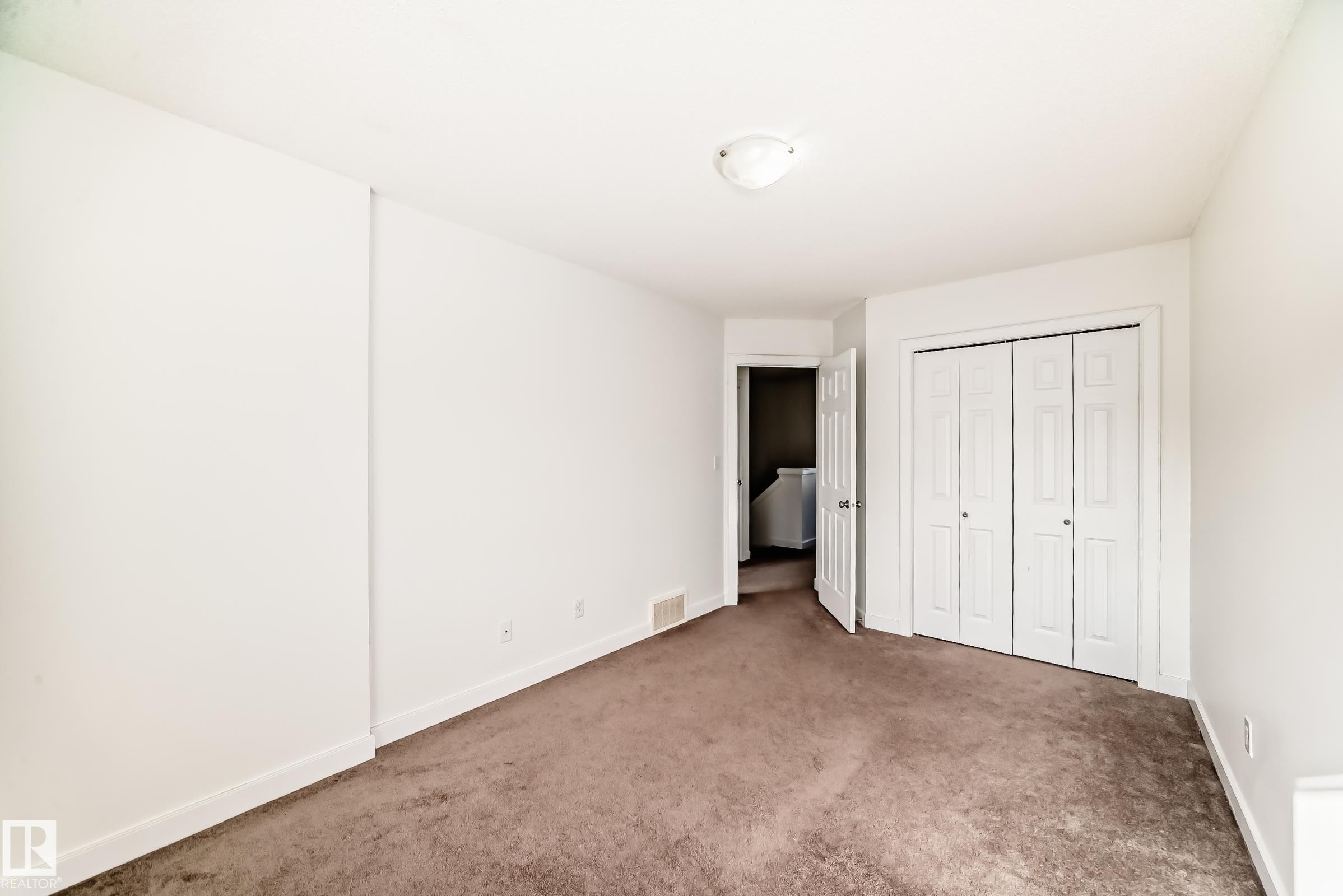Unfurnished bedroom with carpet floors and a closet - 17357 8A Avenue, Edmonton, AB