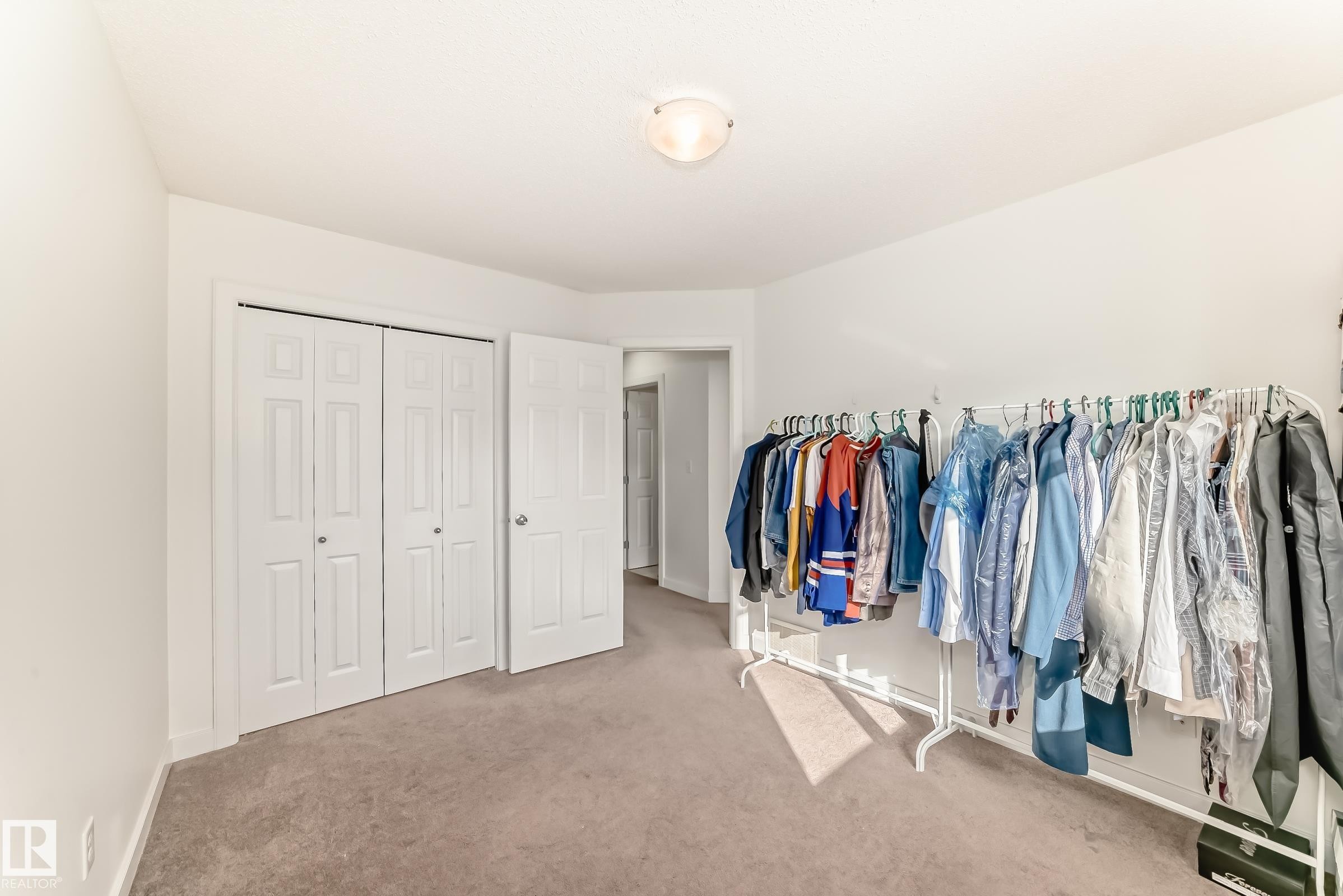 Bedroom with light colored carpet and a closet - 17357 8A Avenue, Edmonton, AB
