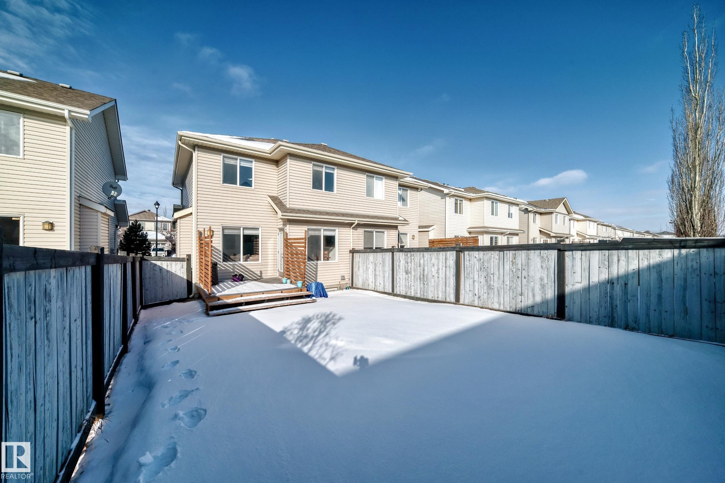 Back of house featuring a wooden deck, a residential view, and a fenced backyard - 17357 8A Avenue, Edmonton, AB