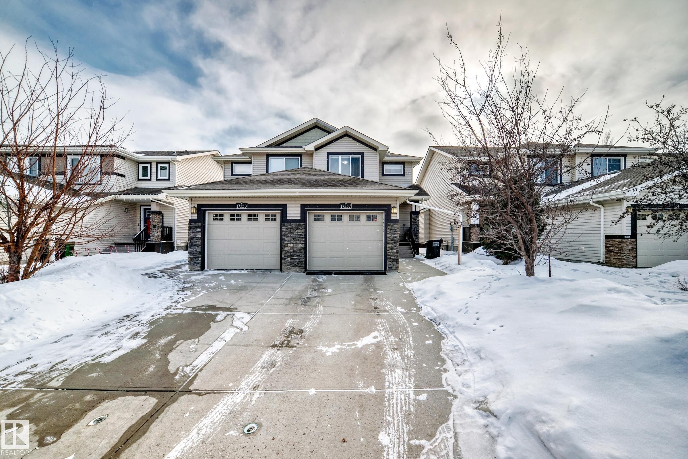 View of front of home featuring a garage, stone siding, concrete driveway, and a shingled roof - 17357 8A Avenue, Edmonton, AB
