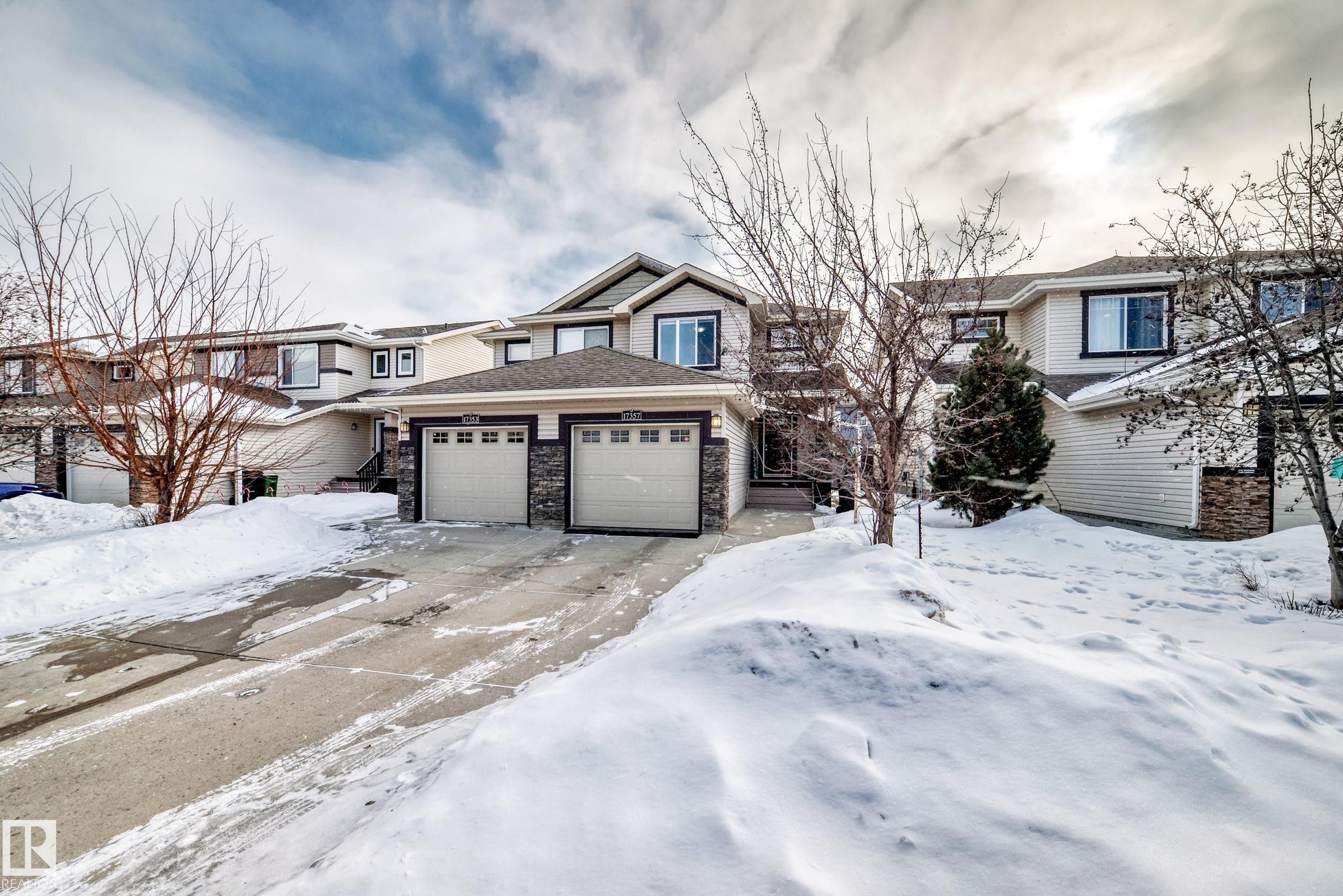 View of front of house with a garage and stone siding - 17357 8A Avenue, Edmonton, AB