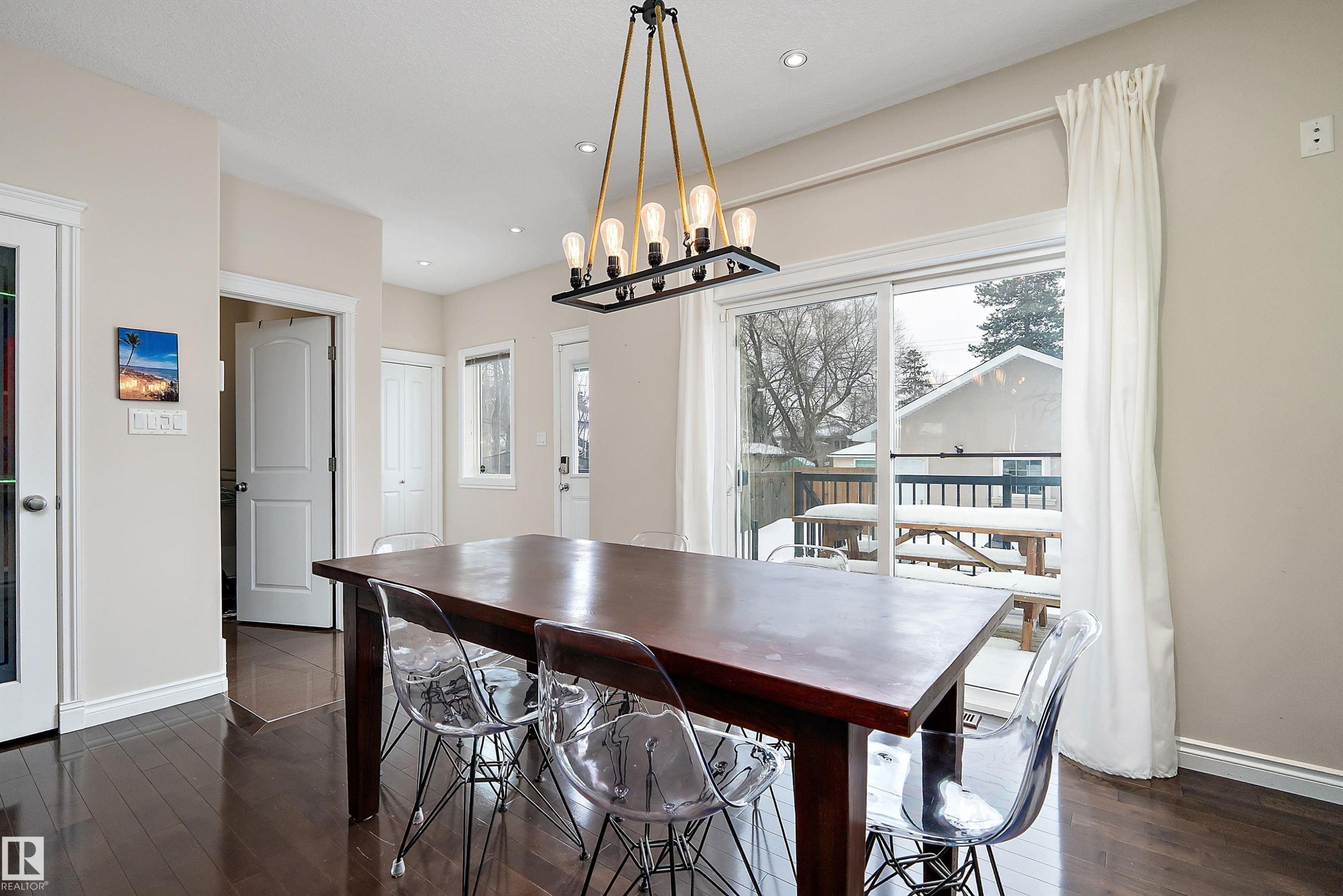 Dining space featuring dark wood-style floors and suspended lighting - 10623 75 Avenue, Edmonton, AB - Indoor Photo Showing Dining Room