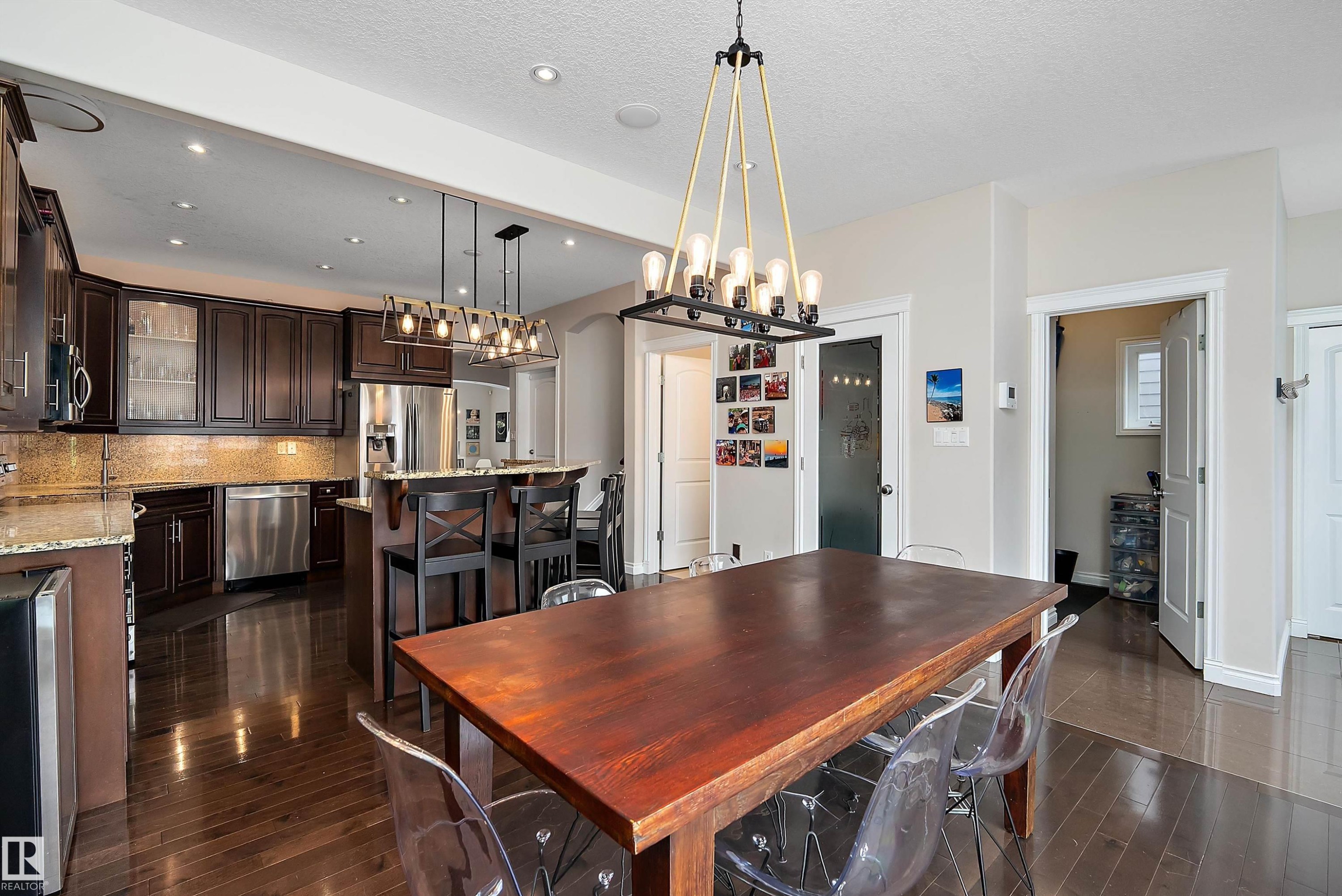Dining room with dark wood finished floors, a textured ceiling, beverage cooler, and hanging lights - 10623 75 Avenue, Edmonton, AB - Indoor
