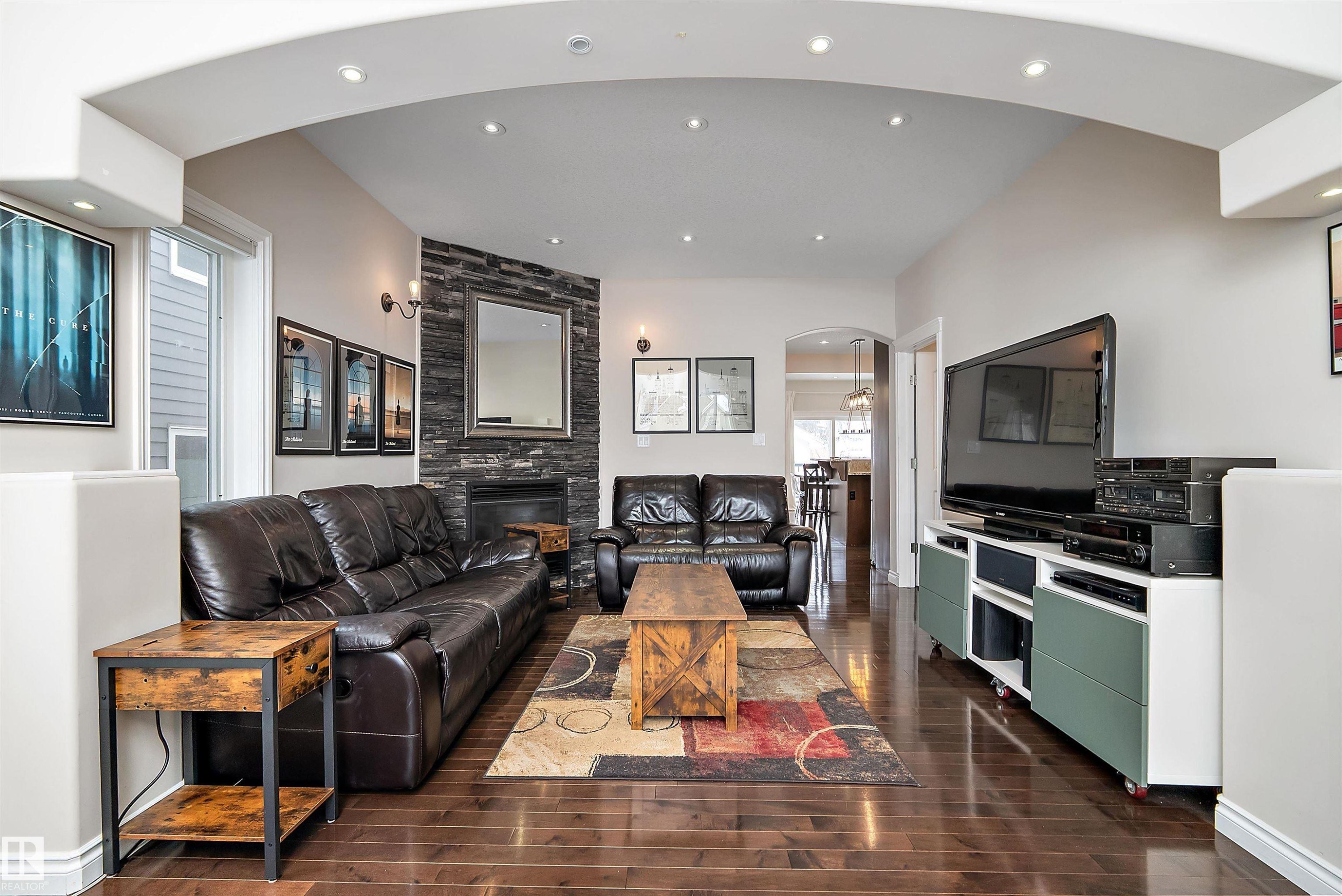 Living room with arched walkways, recessed lighting, a large fireplace, and dark wood finished floors - 10623 75 Avenue, Edmonton, AB - Indoor Photo Showing Living Room With Fireplace