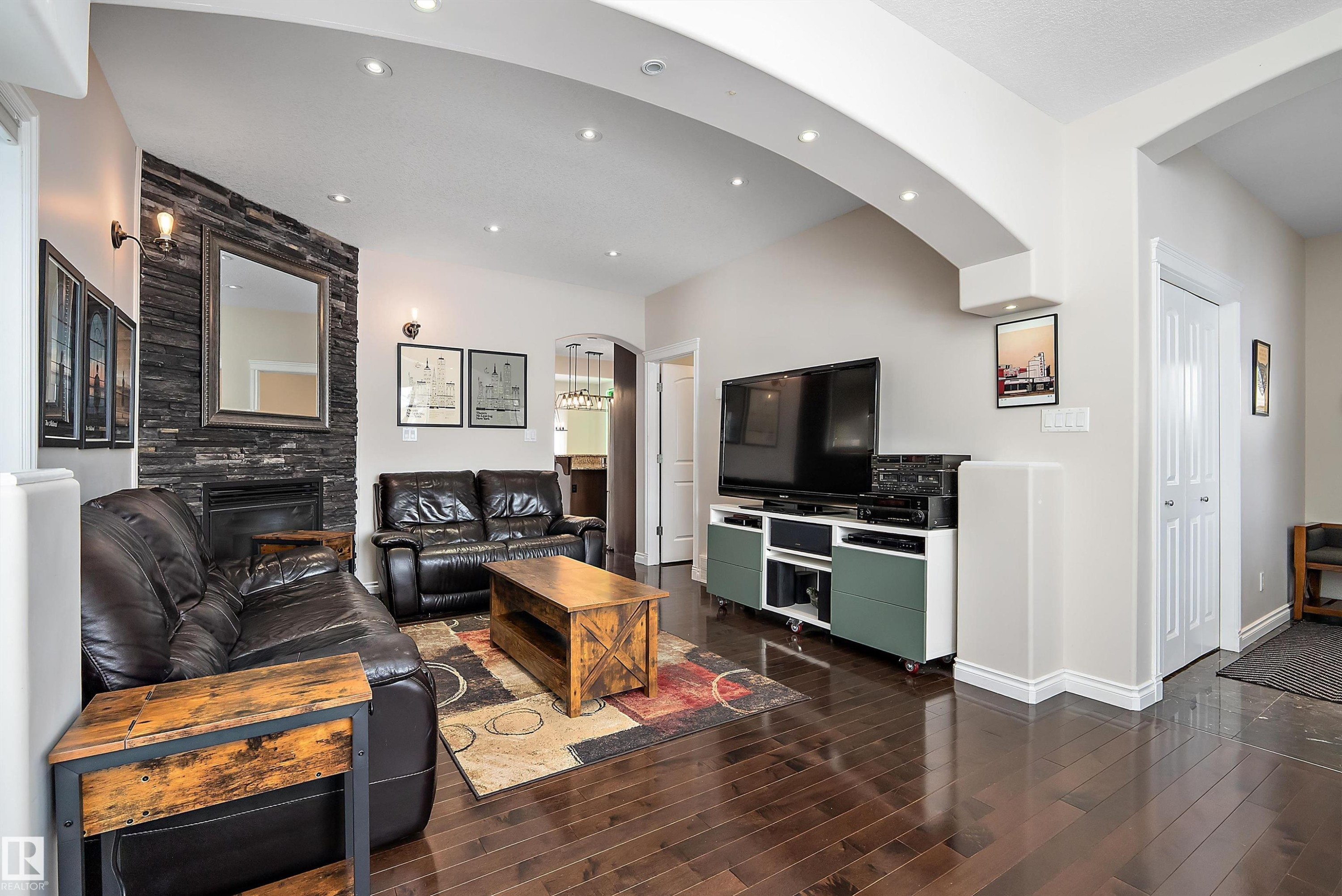 Living area with arched walkways, a fireplace, dark wood-style floors, and recessed lighting - 10623 75 Avenue, Edmonton, AB - Indoor