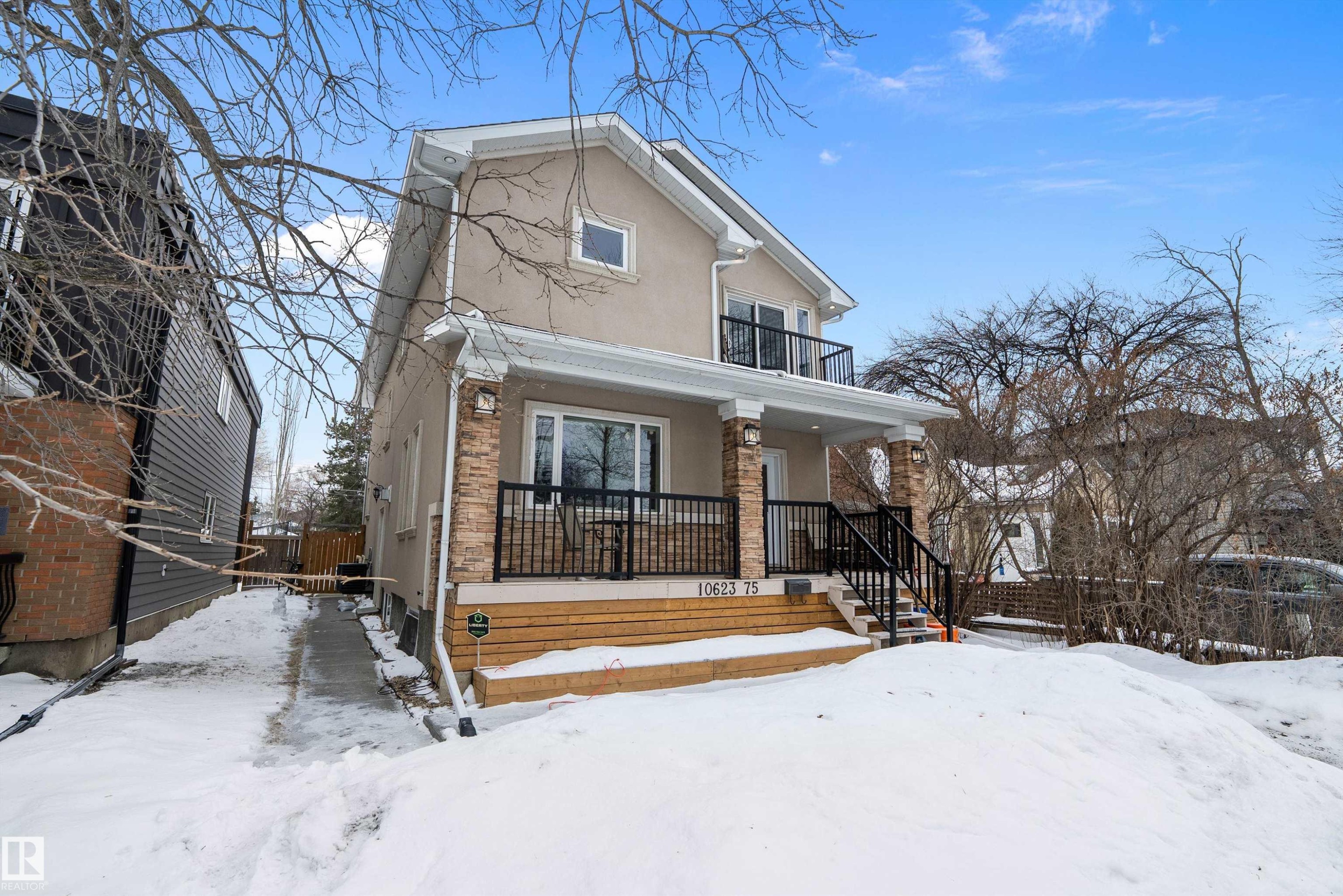 View of front of property featuring stucco siding, a balcony, and covered porch - 10623 75 Avenue, Edmonton, AB - Outdoor
