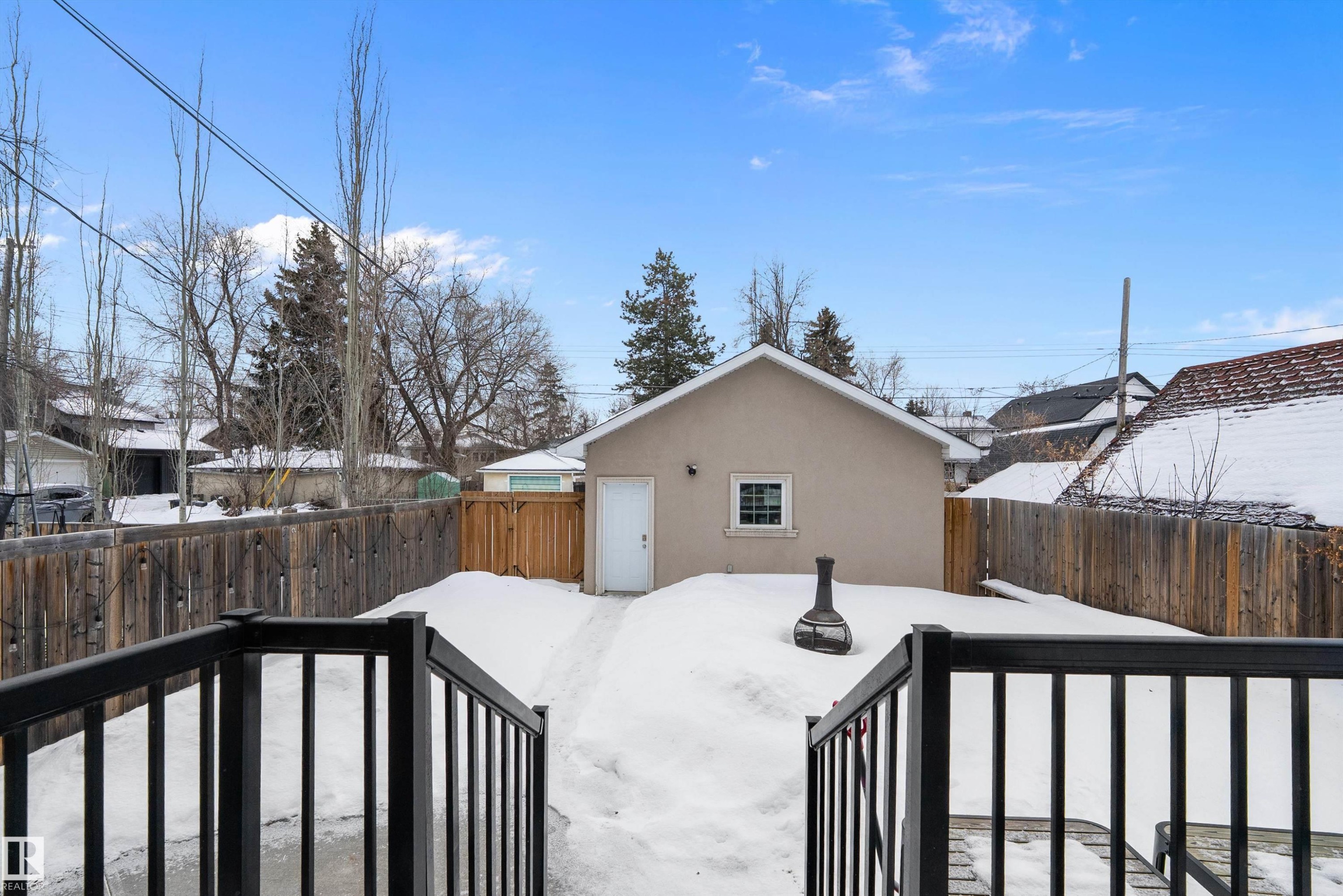 Yard layered in snow with a deck and a fenced backyard - 10623 75 Avenue, Edmonton, AB - Outdoor With Exterior