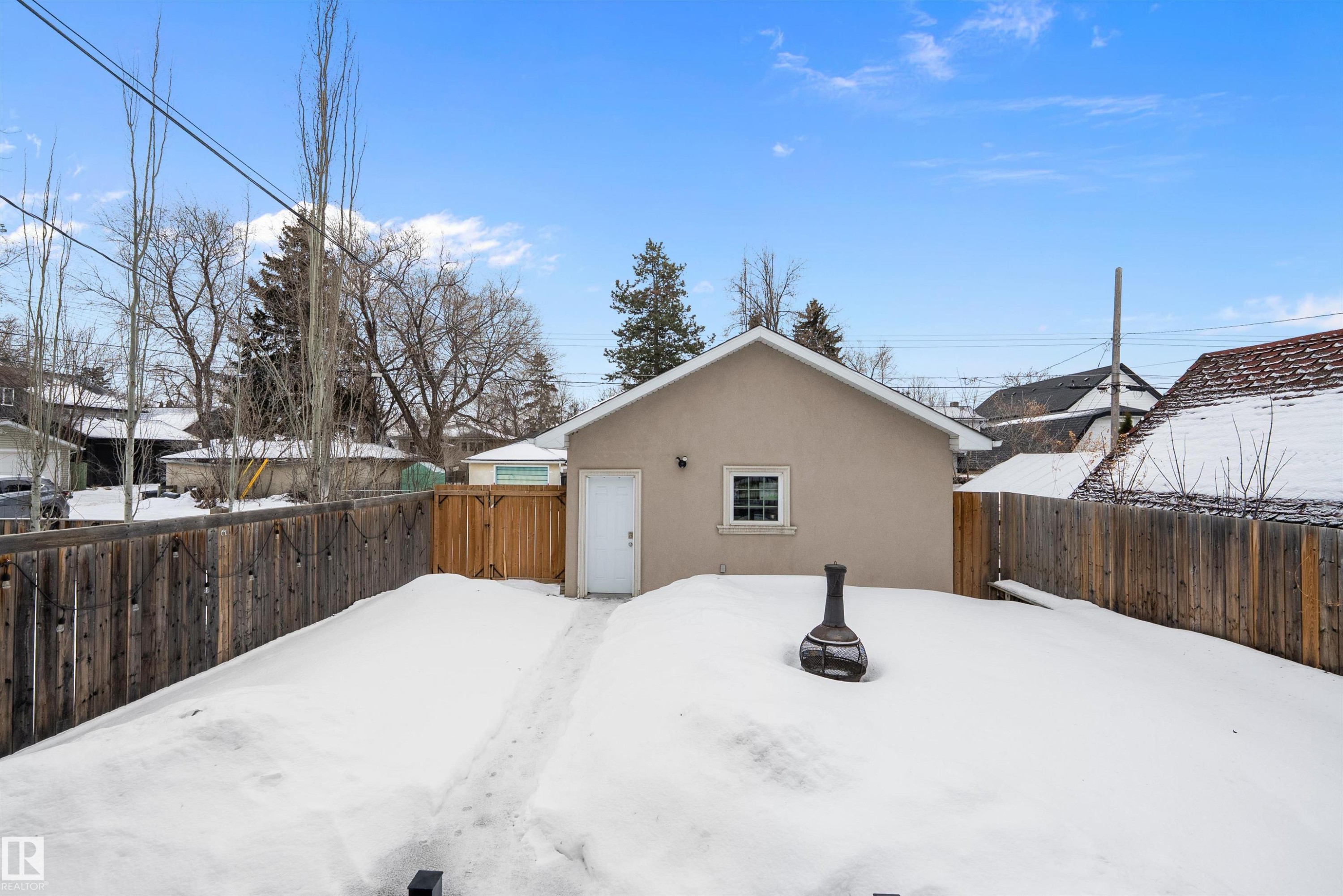 View of snow covered exterior featuring stucco siding and a fenced backyard - 10623 75 Avenue, Edmonton, AB - Outdoor