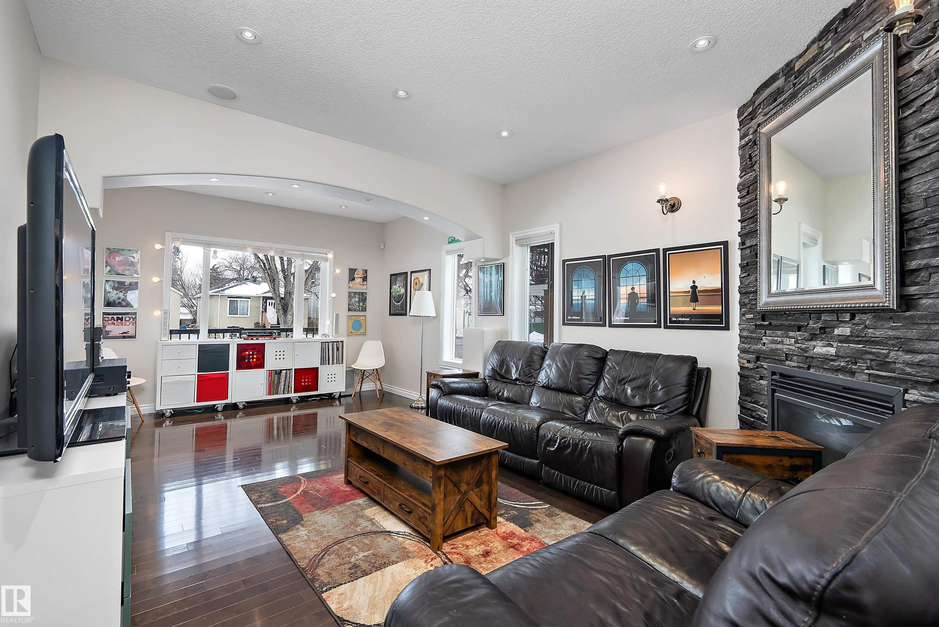 Living room featuring arched walkways, a fireplace, dark wood-style flooring, and recessed lighting - 10623 75 Avenue, Edmonton, AB - Indoor Photo Showing Living Room