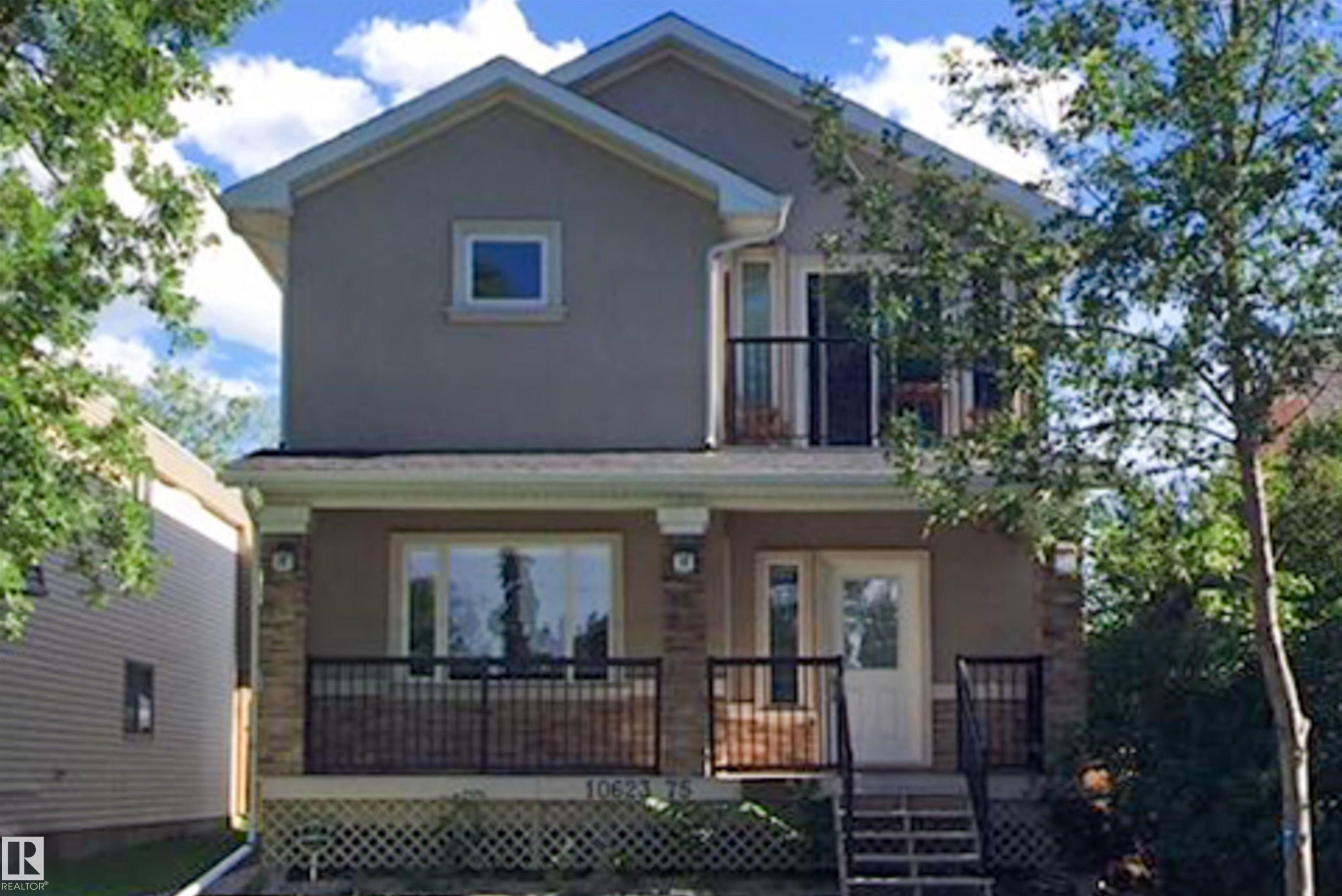View of front of home with stucco siding, a balcony, and covered porch - 10623 75 Avenue, Edmonton, AB - Outdoor With Deck Patio Veranda