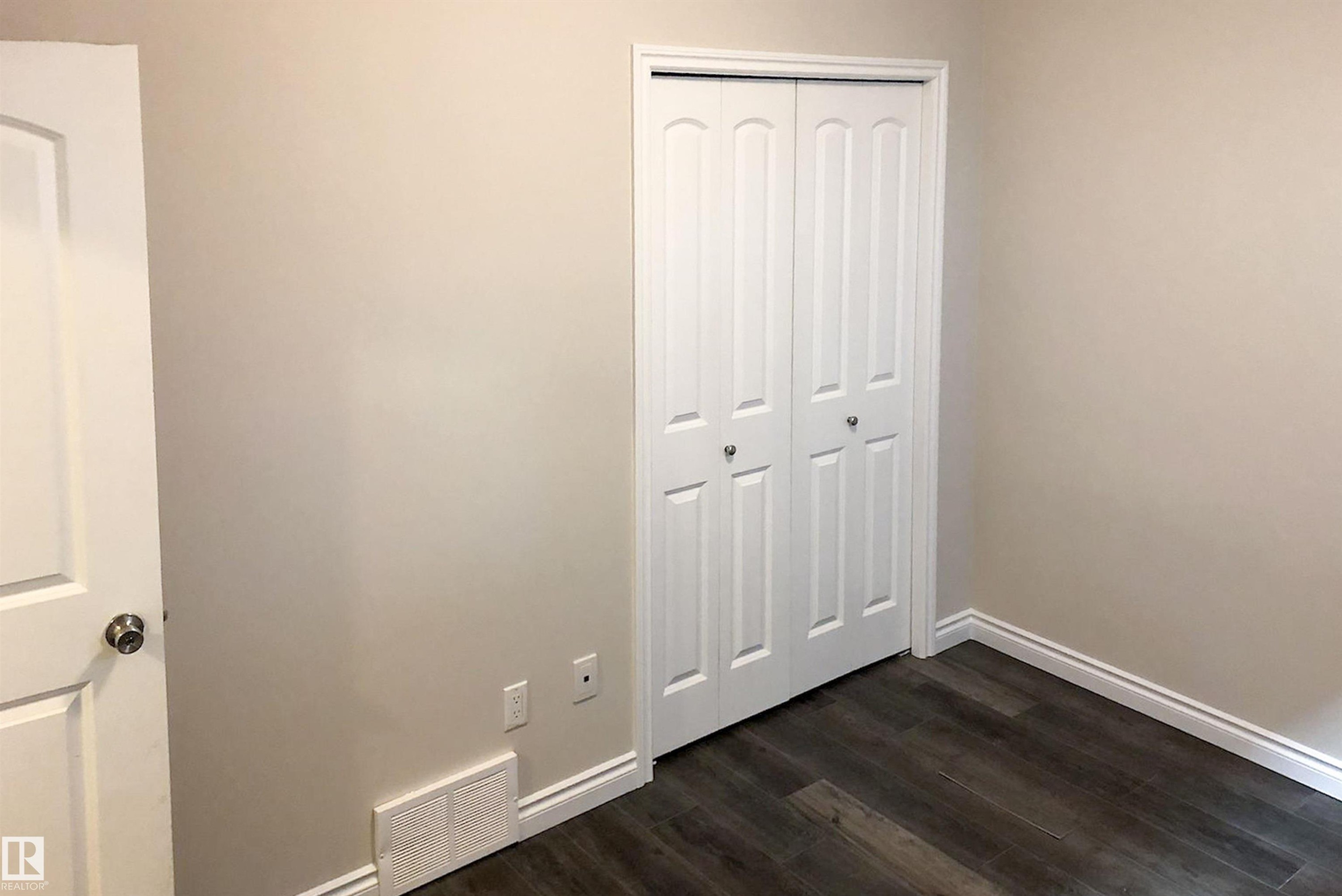 Unfurnished bedroom featuring dark wood-style flooring and a closet - 10623 75 Avenue, Edmonton, AB - Indoor Photo Showing Other Room