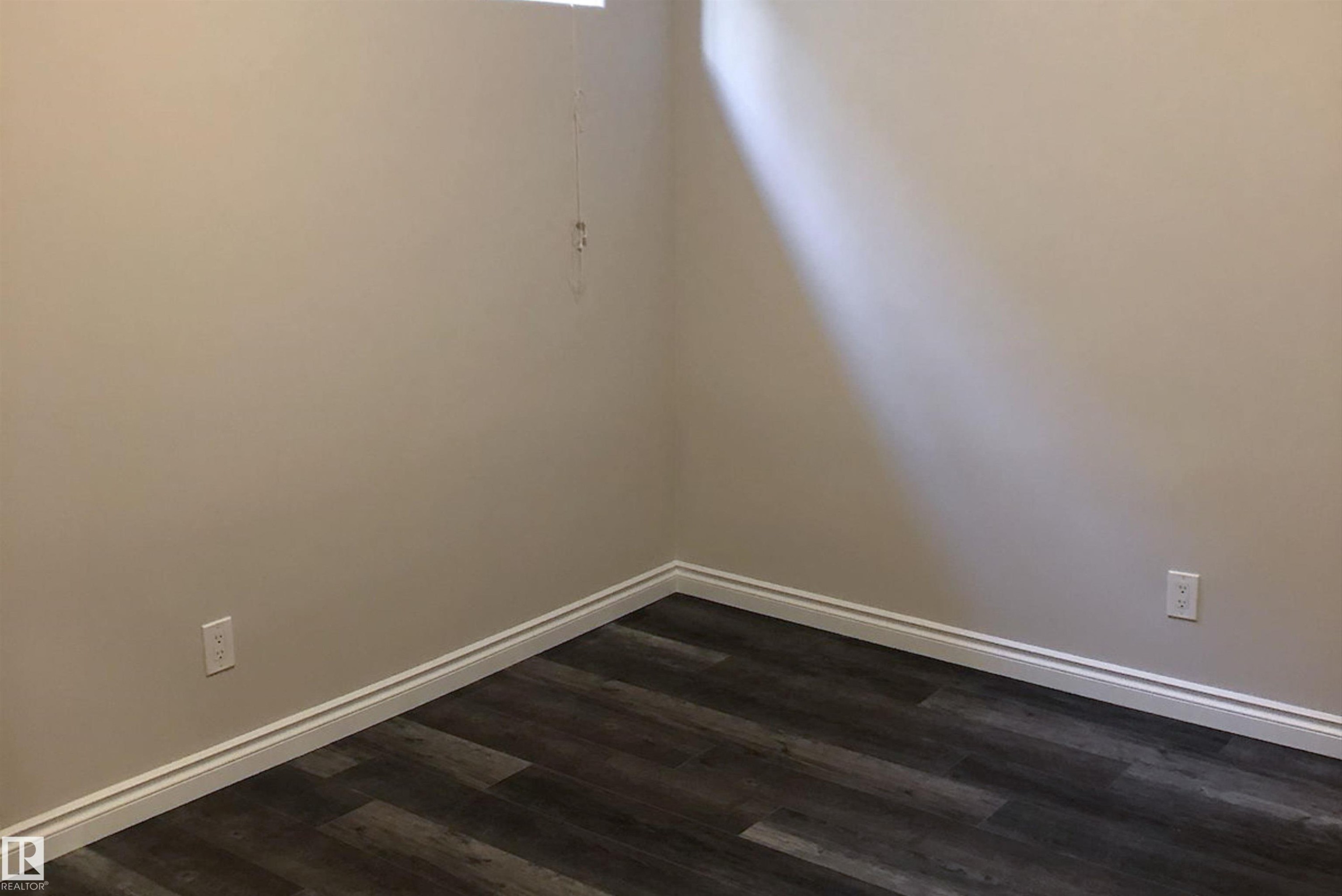 Empty room with baseboards and dark wood-style flooring - 10623 75 Avenue, Edmonton, AB - Indoor Photo Showing Other Room
