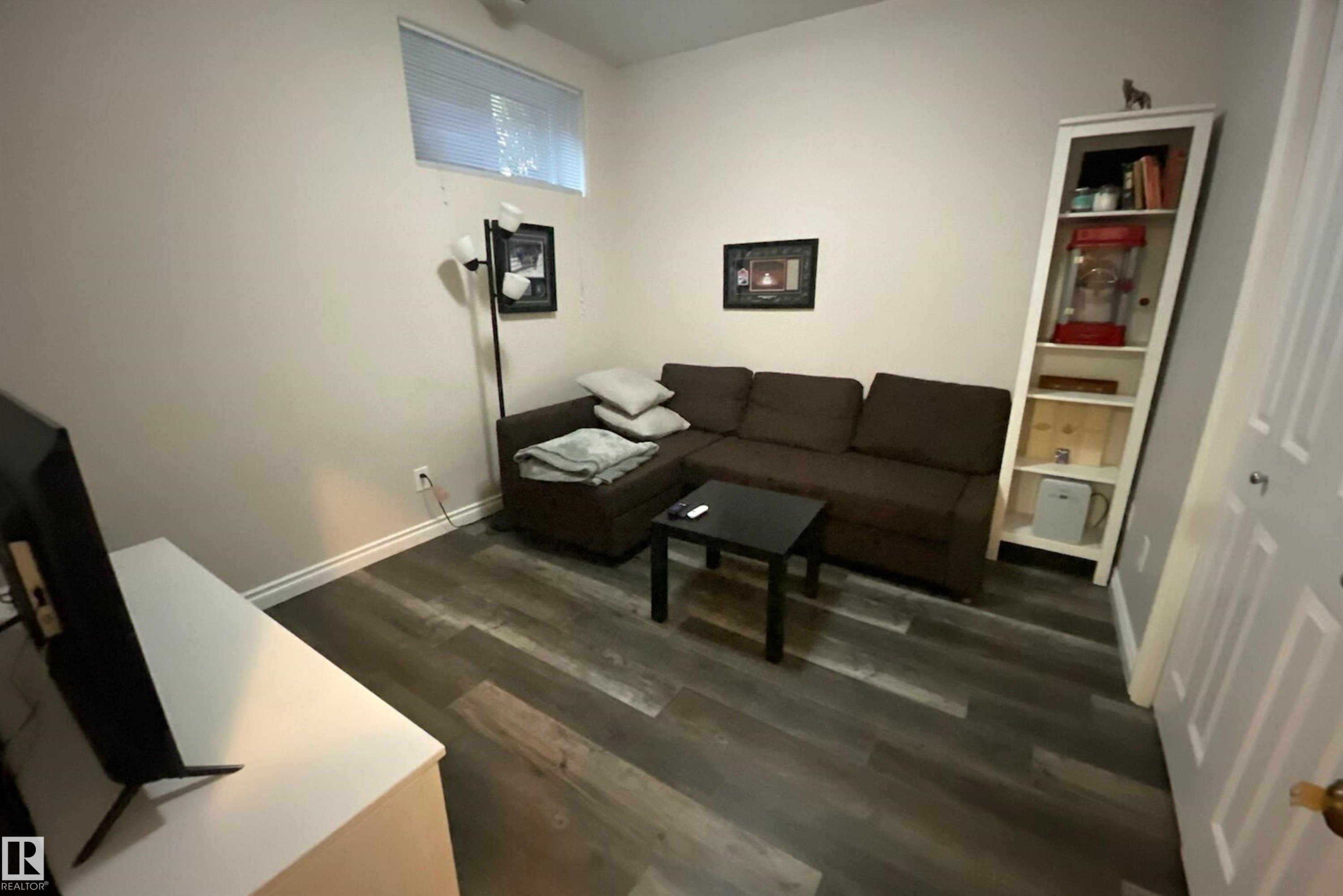 Living area featuring dark wood-style floors and baseboards - 10623 75 Avenue, Edmonton, AB - Indoor