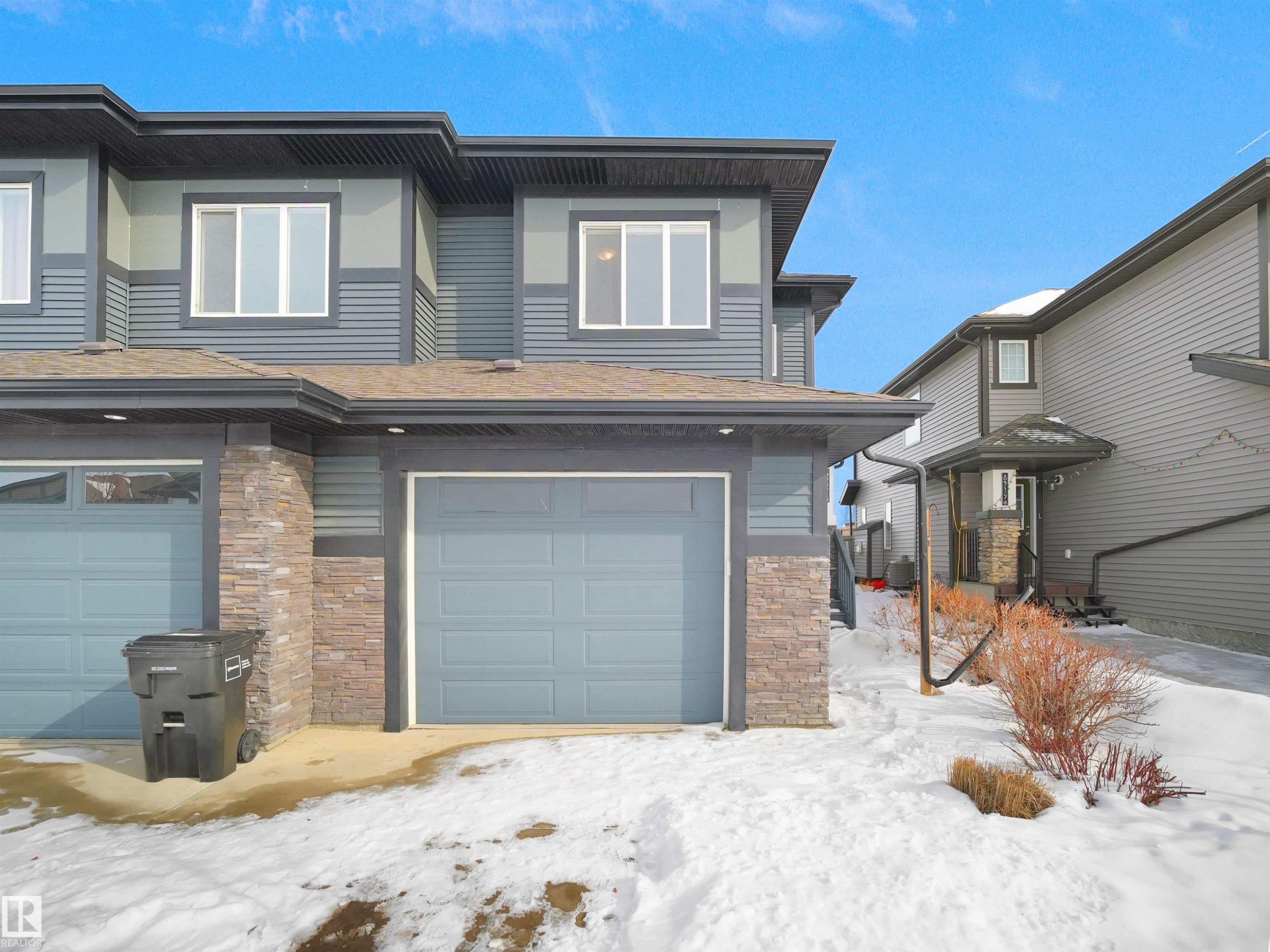 View of front of home featuring stone siding and a garage - 8921 217 St Nw, Edmonton, AB - Outdoor