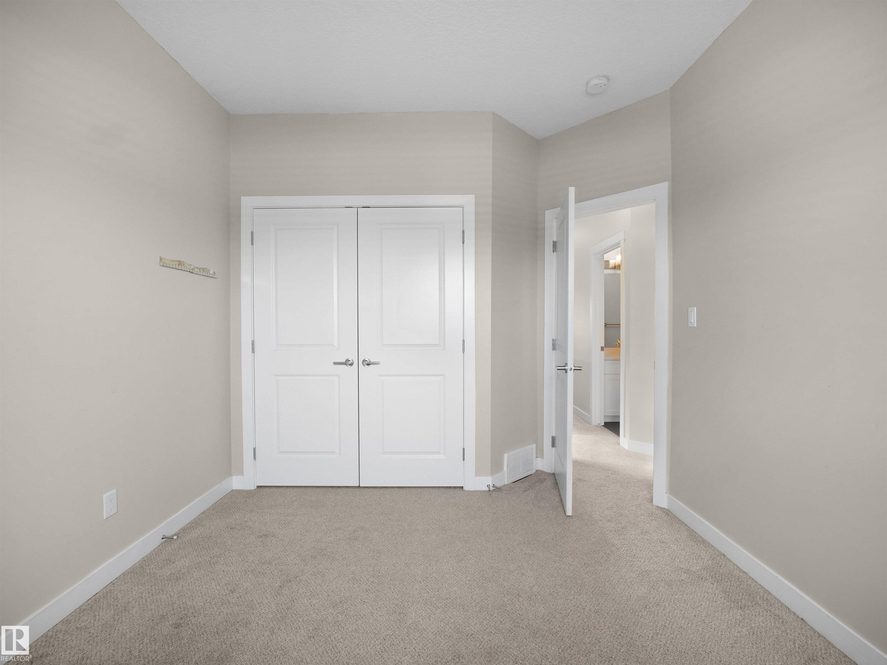 Unfurnished bedroom featuring light carpet and a closet - 8921 217 St Nw, Edmonton, AB - Indoor Photo Showing Other Room