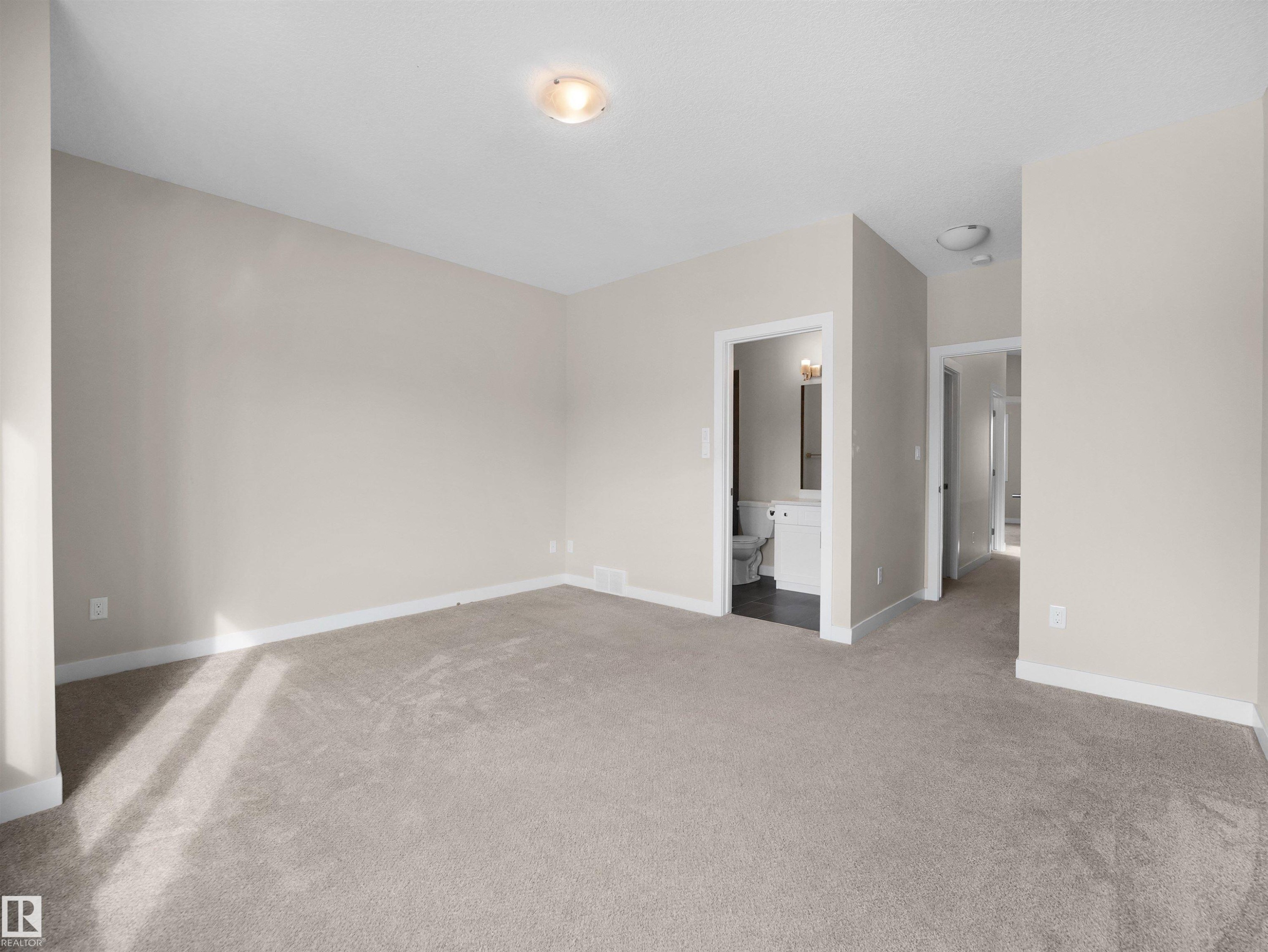 Unfurnished bedroom featuring light colored carpet and ensuite bath - 8921 217 St Nw, Edmonton, AB - Indoor Photo Showing Other Room