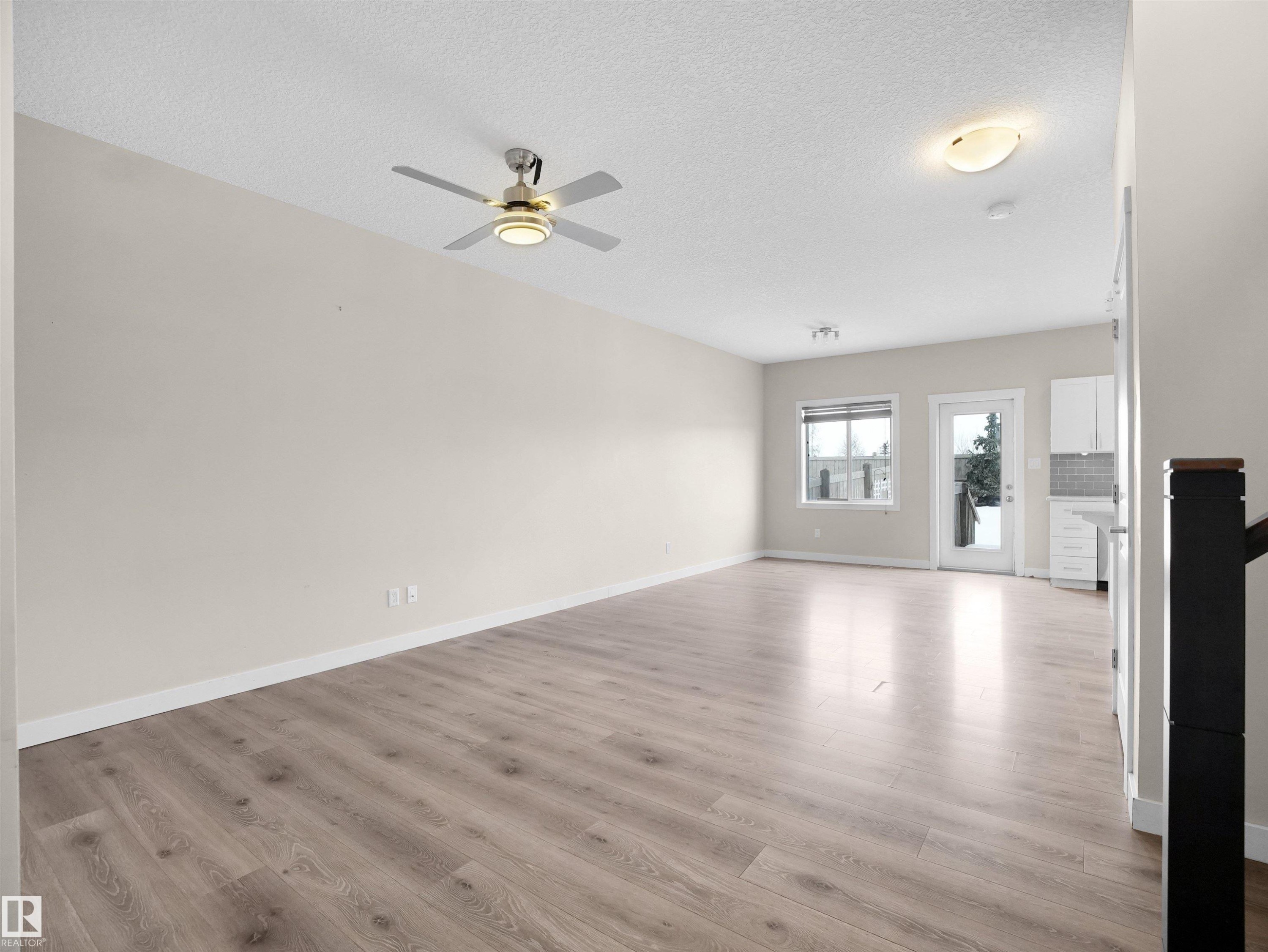 Unfurnished living room with ceiling fan, a textured ceiling, and light wood-style flooring - 8921 217 St Nw, Edmonton, AB - Indoor Photo Showing Other Room