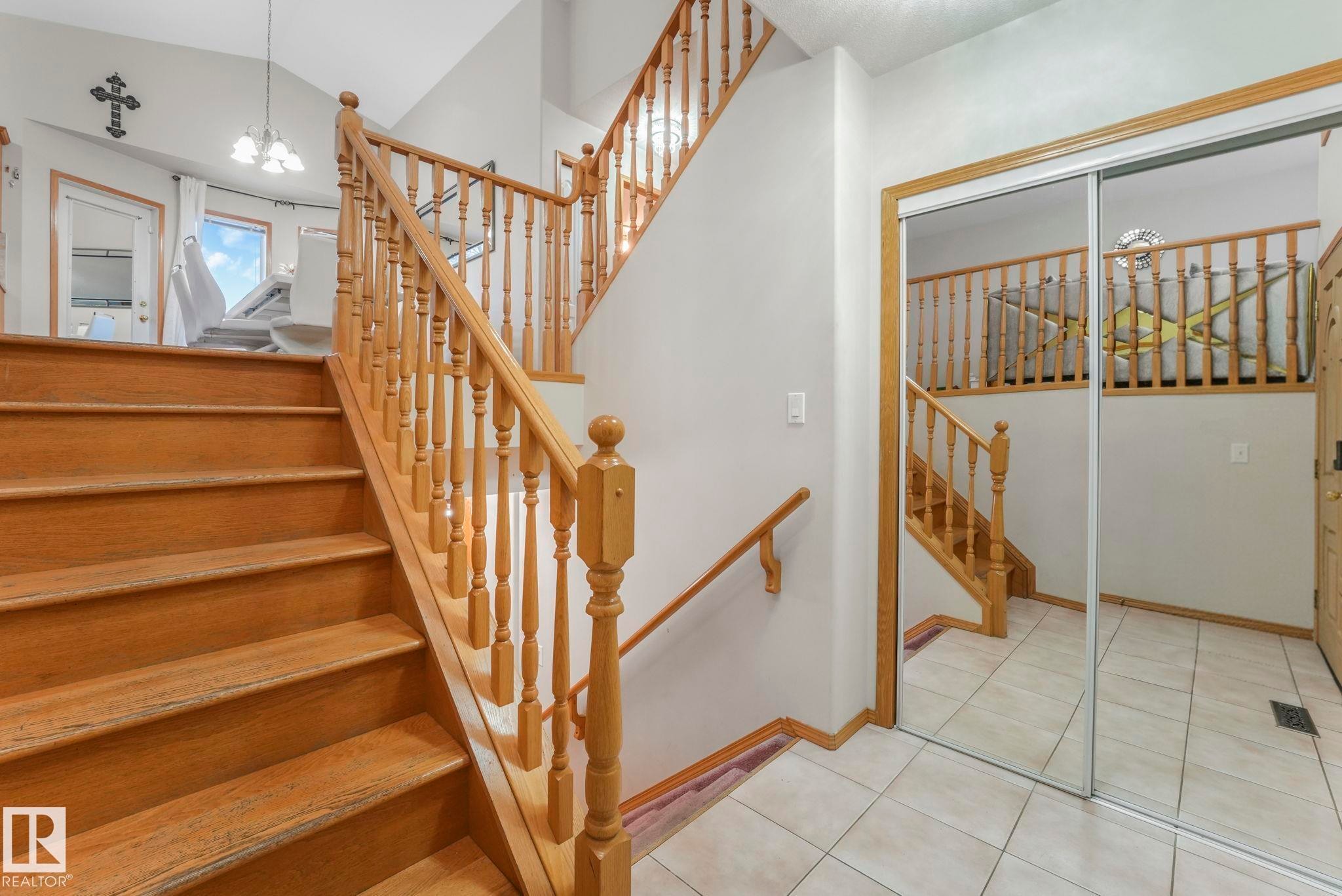 Stairway with tile patterned flooring and a chandelier - 4720 150 Avenue, Edmonton, AB - Indoor Photo Showing Other Room