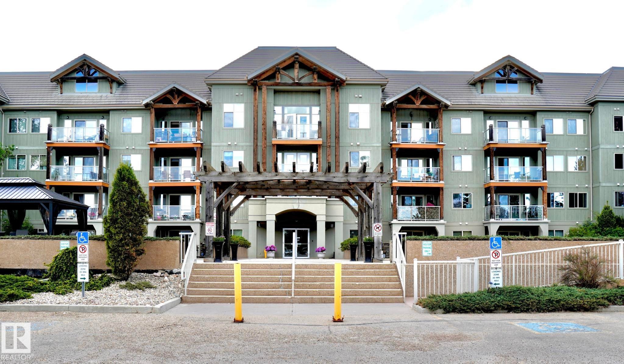 Multi-story residential building featuring light green siding and a dark roof - 237 278 Suder Greens Drive, Edmonton, AB - Outdoor With Facade