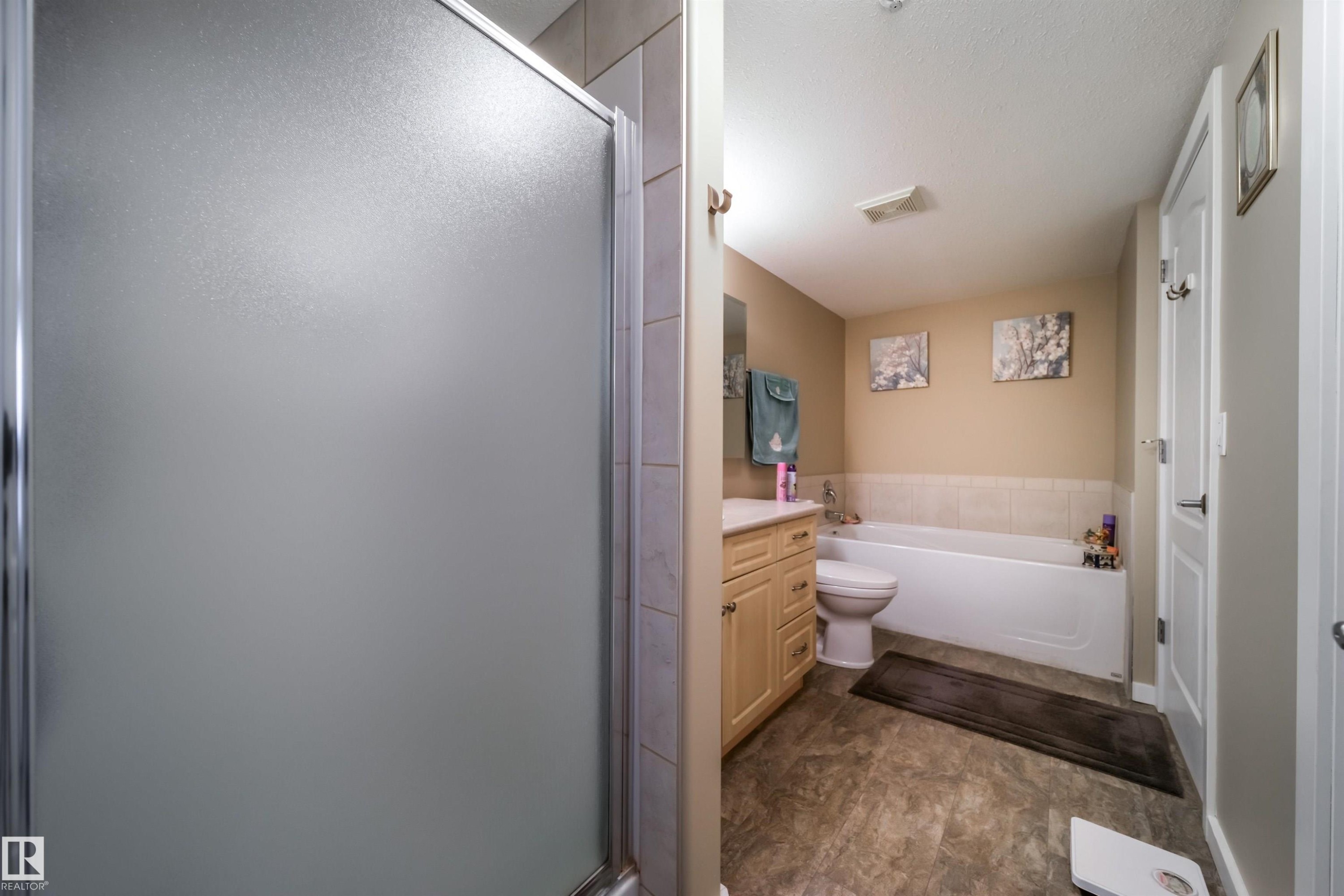 Bathroom featuring vanity, a bath, and a shower stall - 237 278 Suder Greens Drive, Edmonton, AB - Indoor Photo Showing Living Room