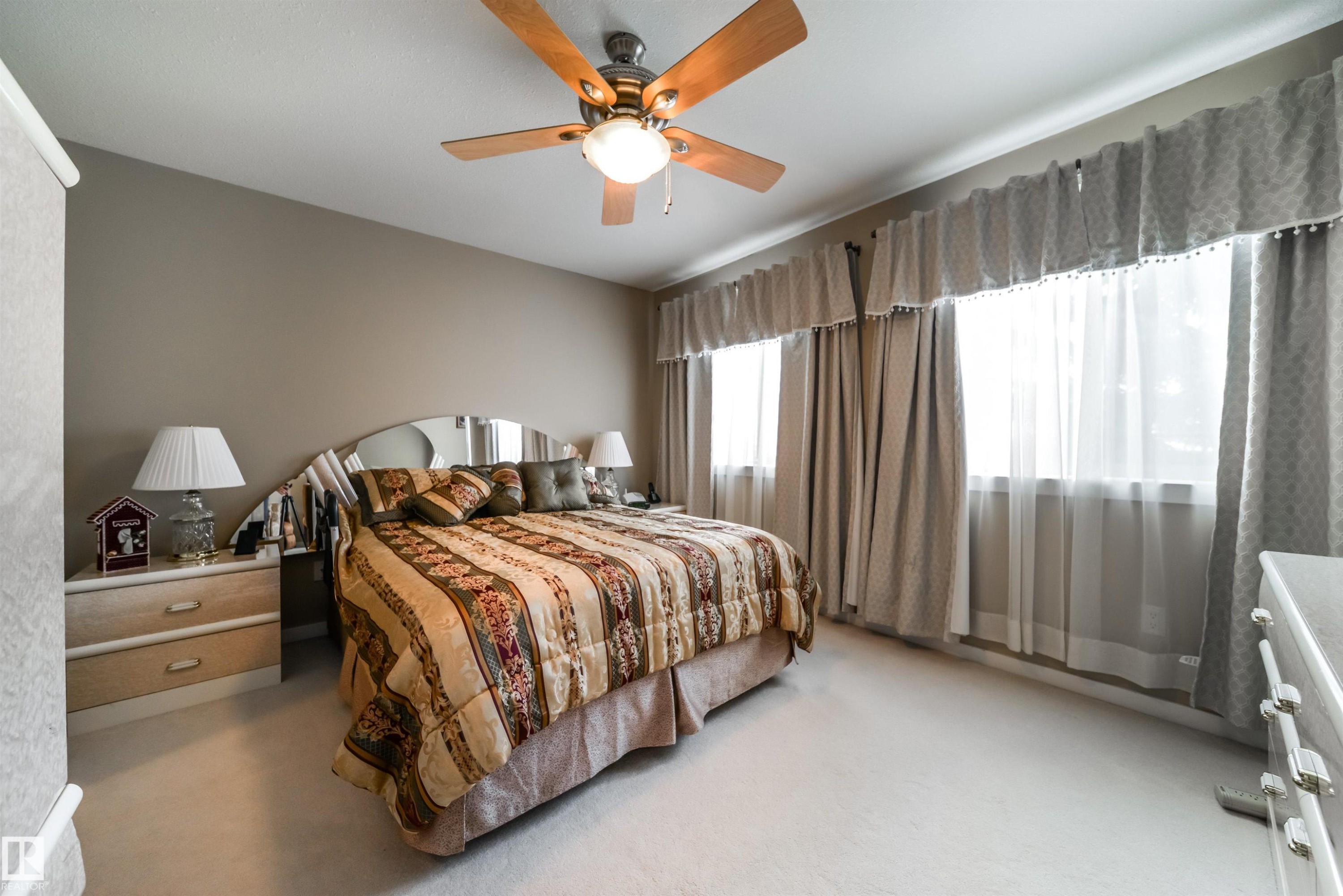 Bedroom with ceiling fan and light carpet - 237 278 Suder Greens Drive, Edmonton, AB - Indoor With Storage