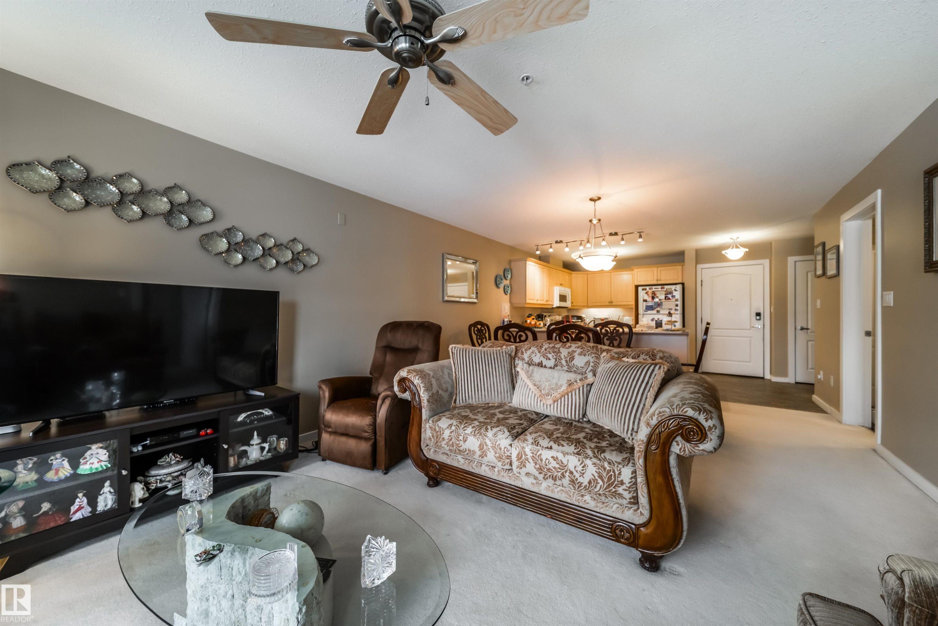 Living room featuring light carpet and a ceiling fan - 237 278 Suder Greens Drive, Edmonton, AB - Outdoor